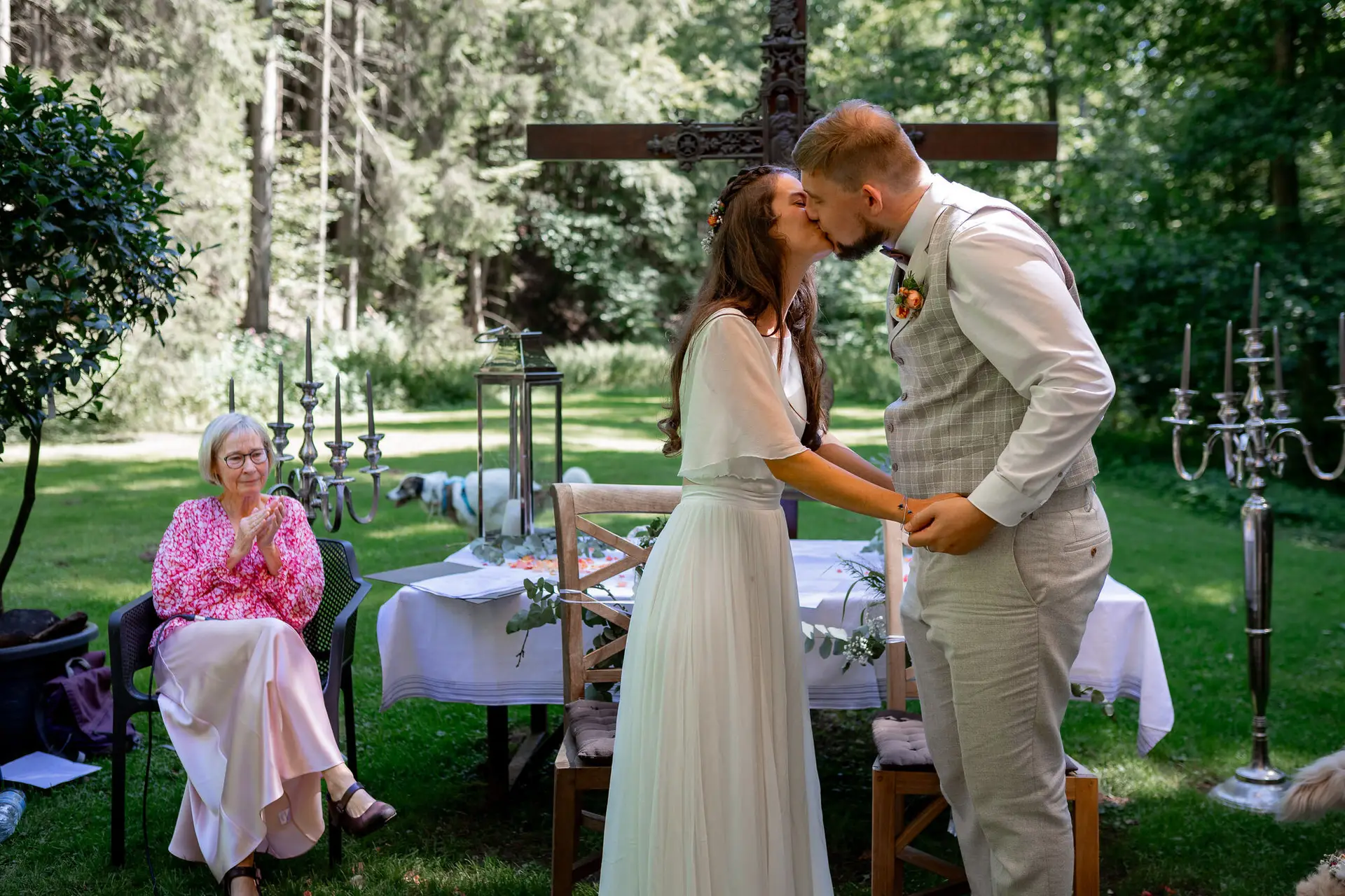 20230811 15 00 25 Hochzeit Elztal Hochzeitsfotograf Heiraten Heidelberg Landgasthof Heidersbacher Muehle 4K8A1919.Cg1p7c0R Der erste Kuss als Ehepaar – innig und glücklich vor dem Holzkreuz, umgeben vom Elztal-Grün