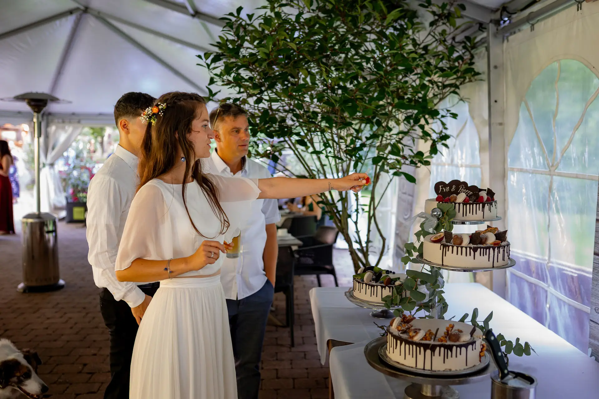 20230811 16 17 31 Hochzeit Elztal Hochzeitsfotograf Heiraten Heidelberg Landgasthof Heidersbacher Muehle 4K8A5124 Verbessert RR.BO5hUMl Brautpaar steht vor der mehrstöckigen Hochzeitstorte bereit zum Anschneiden