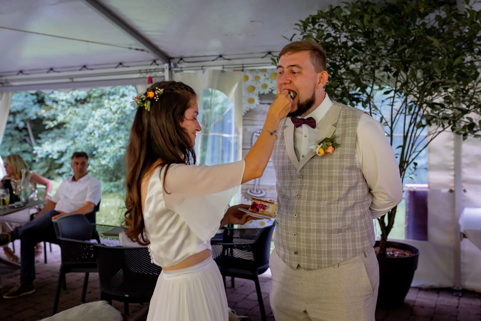 20230811 16 37 59 Hochzeit Elztal Hochzeitsfotograf Heiraten Heidelberg Landgasthof Heidersbacher Muehle 4K8A5655 Verbessert RR.C L0xmzz Bräutigam lacht herzlich, als Braut ihm spaßhaft ein Tortenstück ins Gesicht drückt