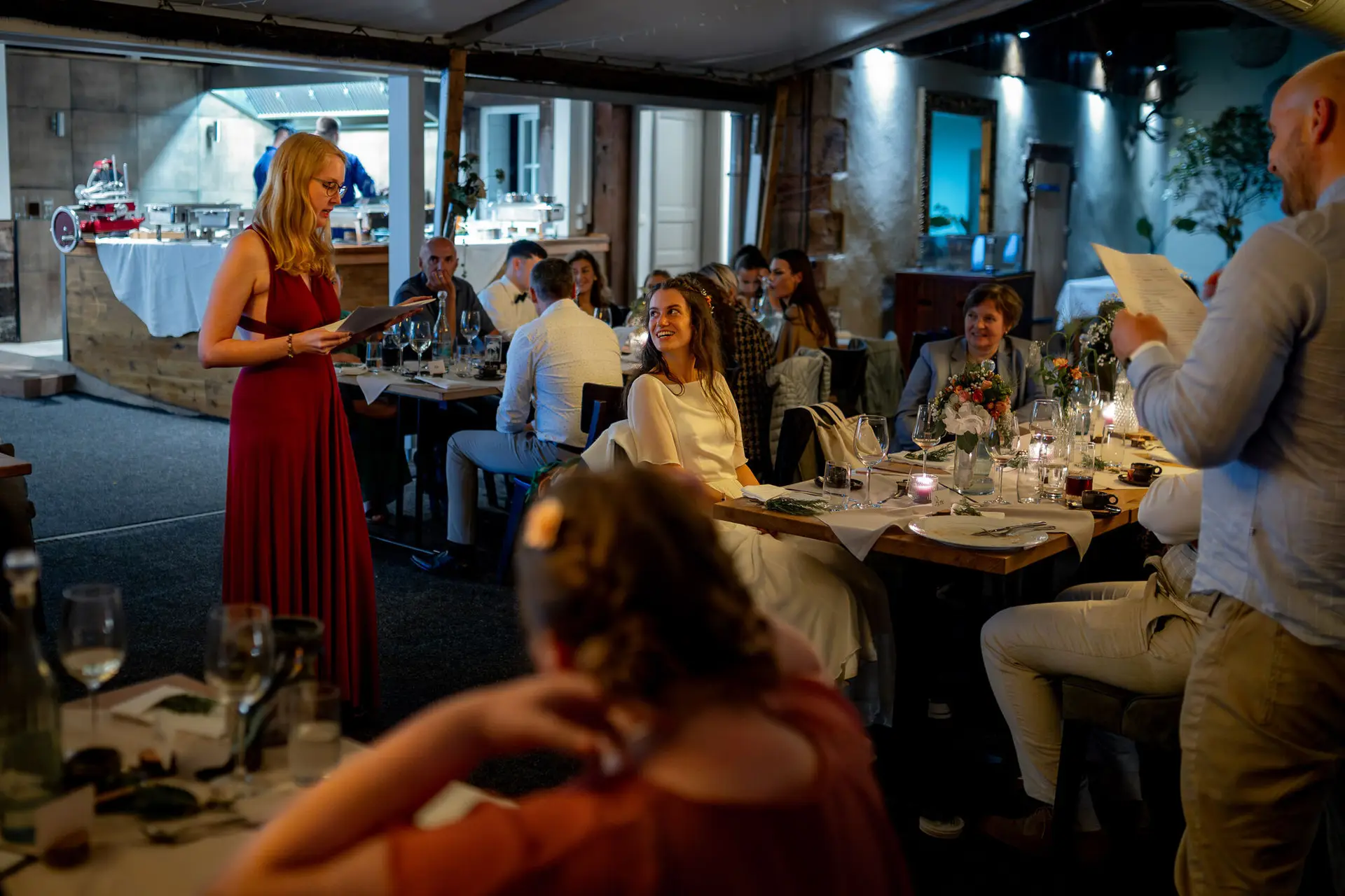 20230811 21 42 49 Hochzeit Elztal Hochzeitsfotograf Heiraten Heidelberg Landgasthof Heidersbacher Muehle 4K8A9235 Verbessert RR.CavfUAEB Brautjungfer in Rot hält eine herzliche Ansprache, Gäste hören aufmerksam zu