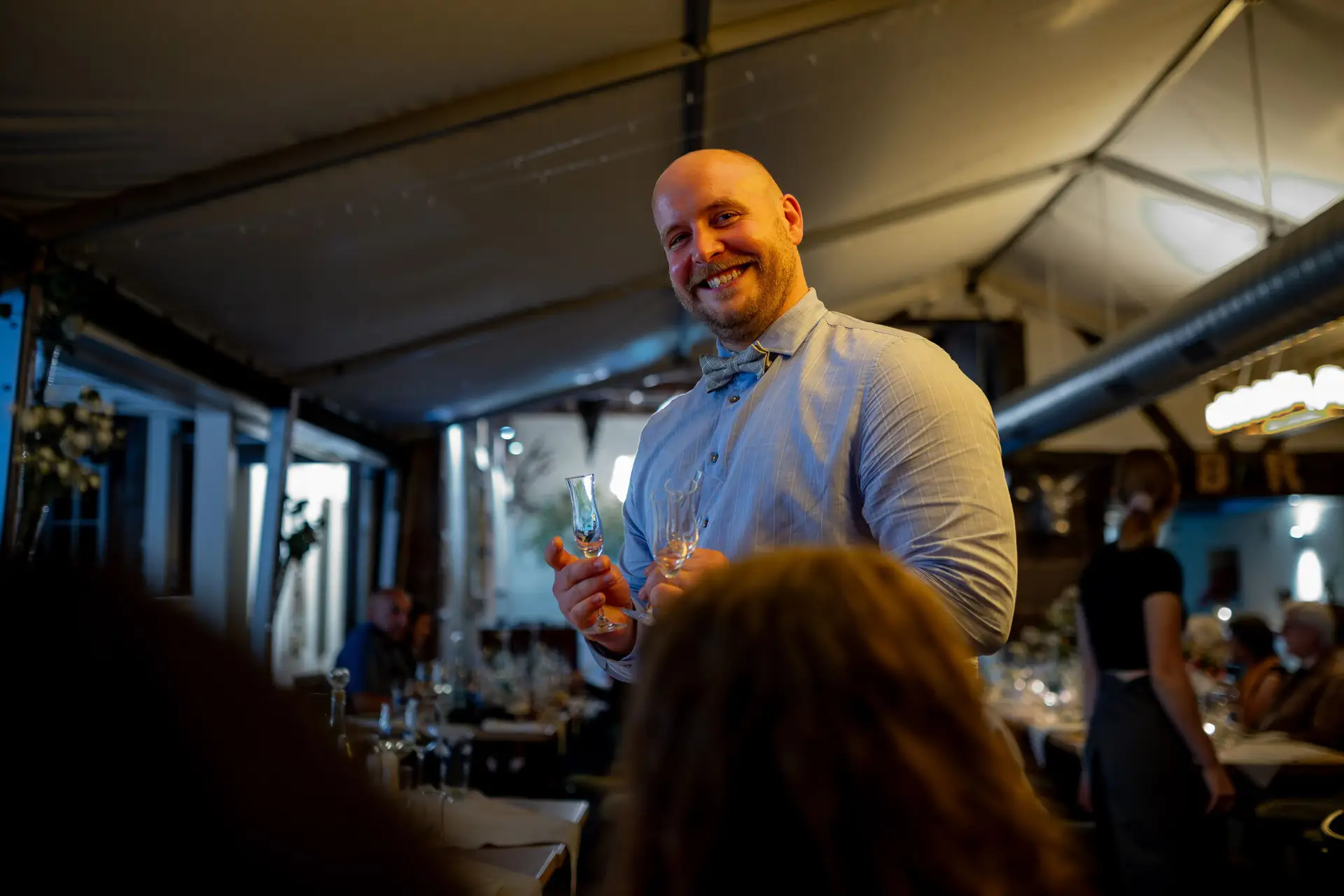 20230811 22 17 35 Hochzeit Elztal Hochzeitsfotograf Heiraten Heidelberg Landgasthof Heidersbacher Muehle 4K8A9348 Verbessert RR.DOpGc2FN Gast mit Glaskolben bei fröhlicher Degustationsrunde beim Hochzeitsabend
