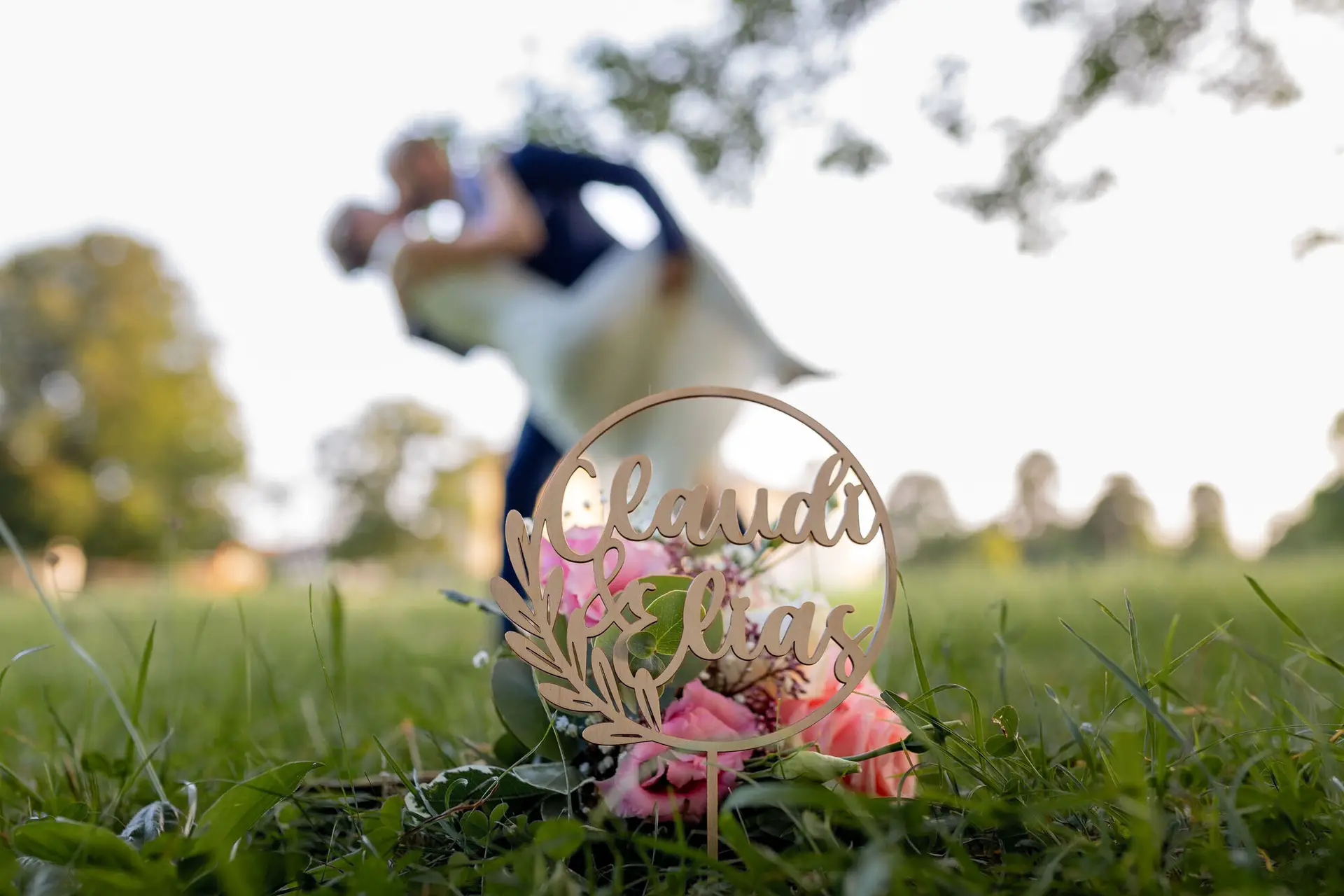20240820 19 32 52 Schlossgarten Worms Herrnsheim 4K8A8638 Hochzeitsfotograf Matthias Butz.IA 8p0YJ Brautpaar liegt in romantischer Umarmung auf einer Wiese, Bäume im Hintergrund unscharf