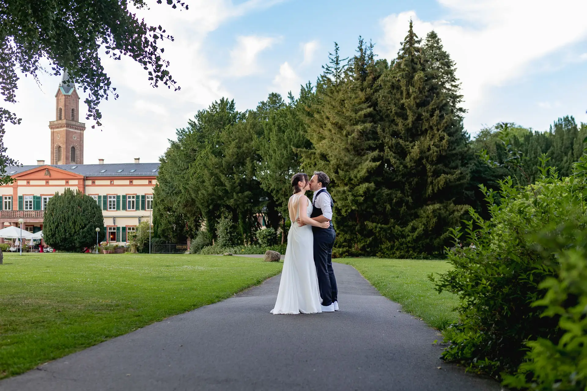Julia und Dennis küssen sich auf grüner Wiese im Schlosspark Weinheim