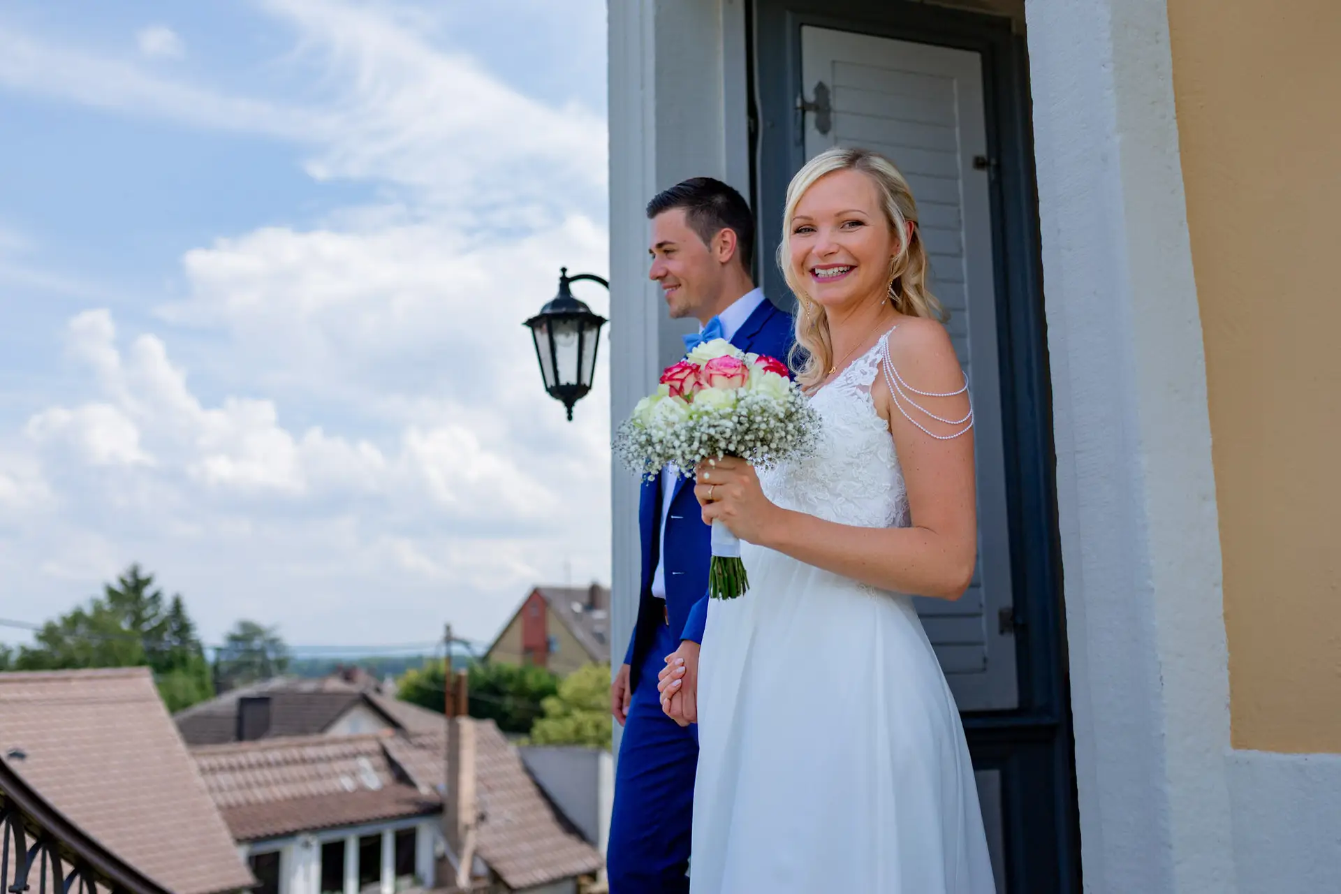 Braut Liane mit Blumenstrauß lacht beim Auszug aus dem Schlosspavillon Kleinniedesheim