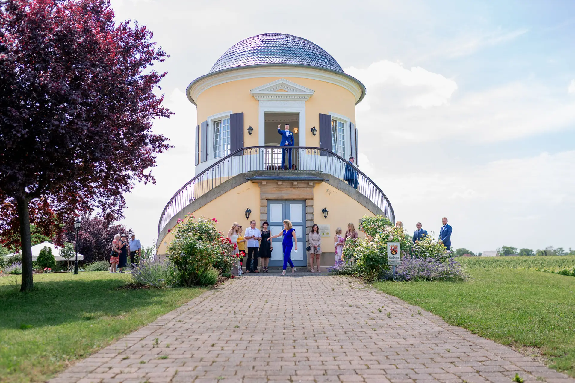 Außenansicht des Schlosspavillon Kleinniedesheim mit Brautpaar und Hochzeitsgesellschaft