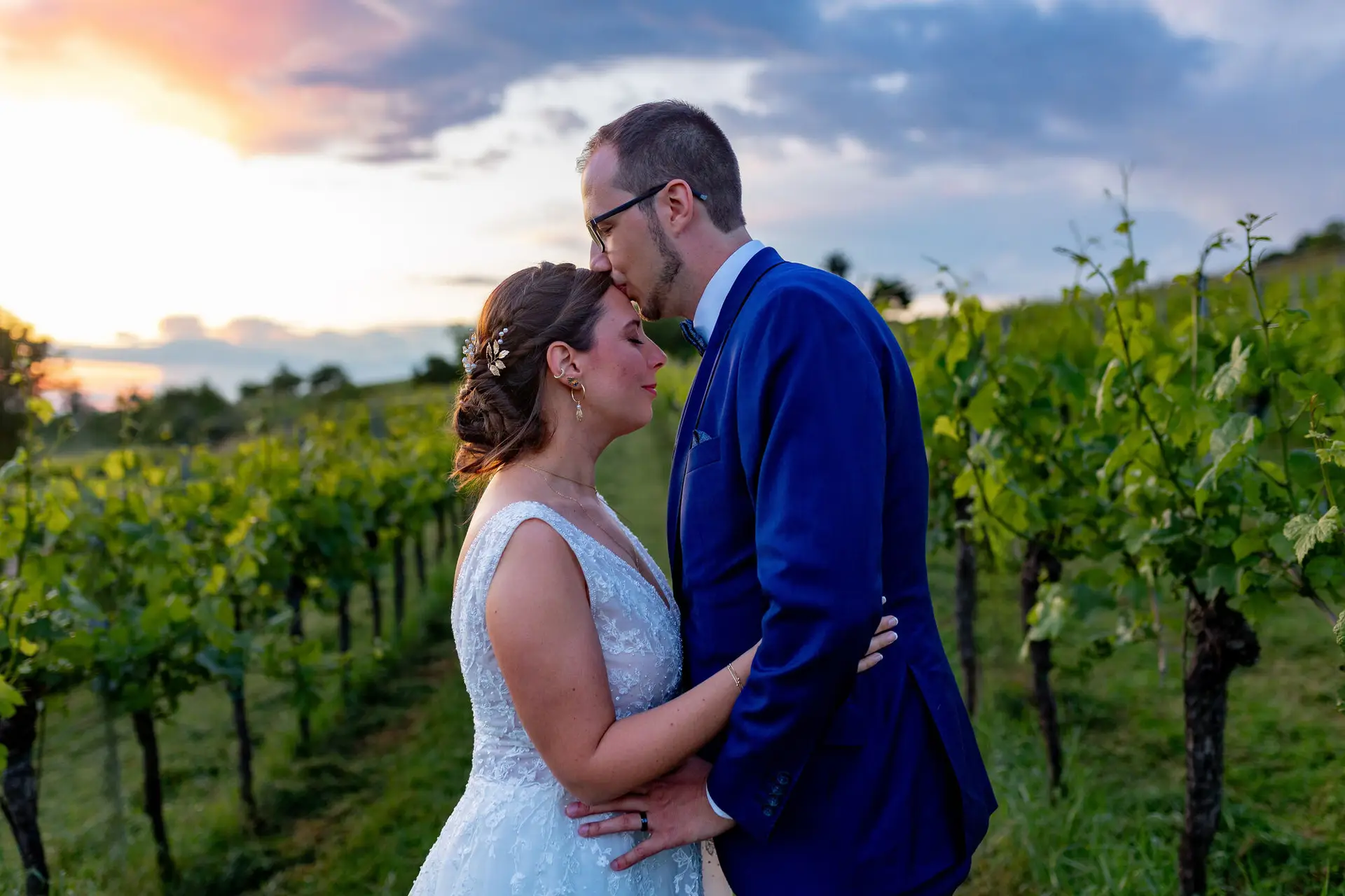 Verena Florian Grenzhof Weinberg Stirnkuss.D2wbs31M Bräutigam küsst seine Braut sanft auf die Stirn im Weinberg bei Abenddämmerung