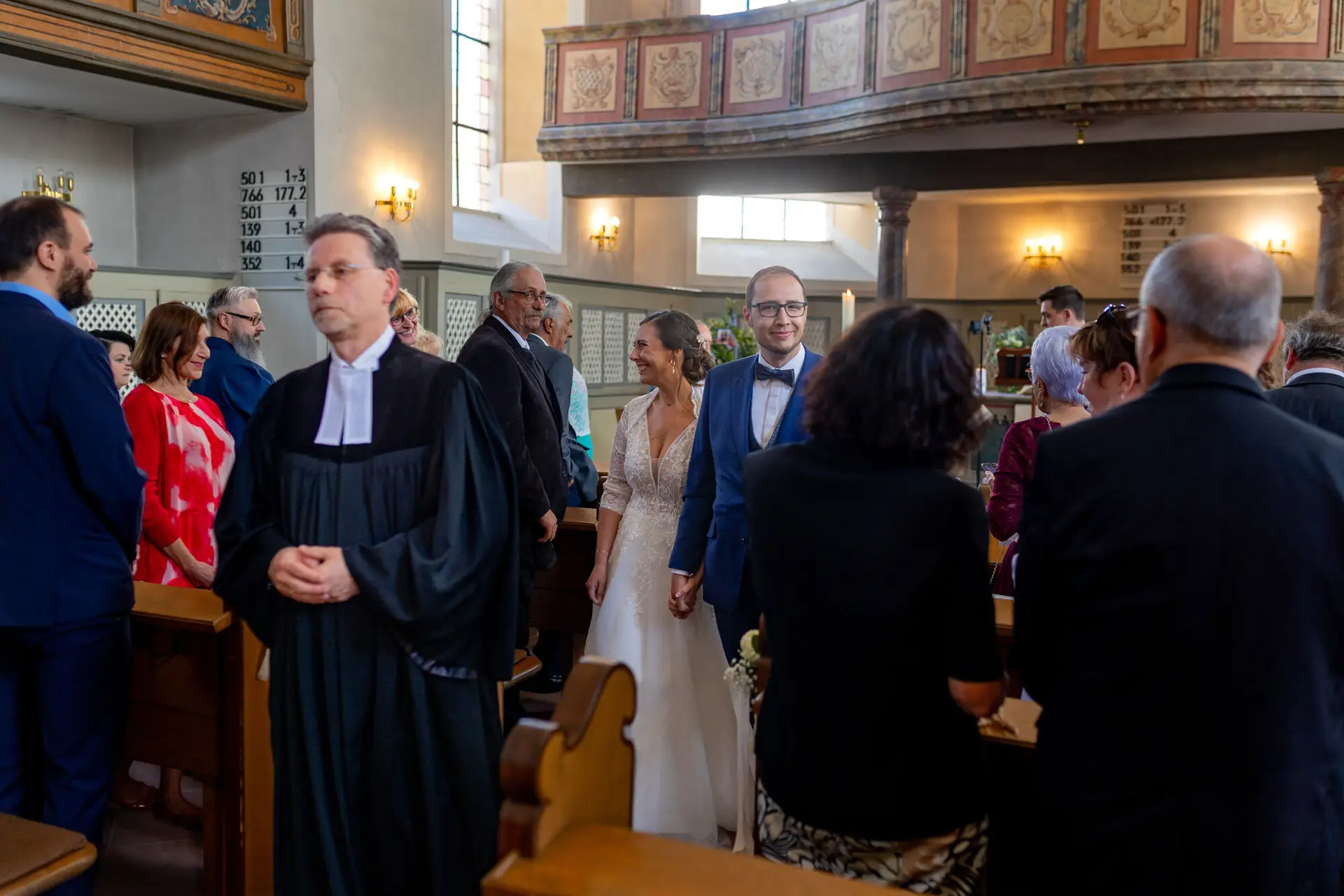 Verena Florian Kirche Mutterstadt Auszug Spalier.CXSLYTKC Brautpaar zieht nach der Trauung durch das Kirchenschiff mit Gewölbedecke aus, Gäste stehen Spalier