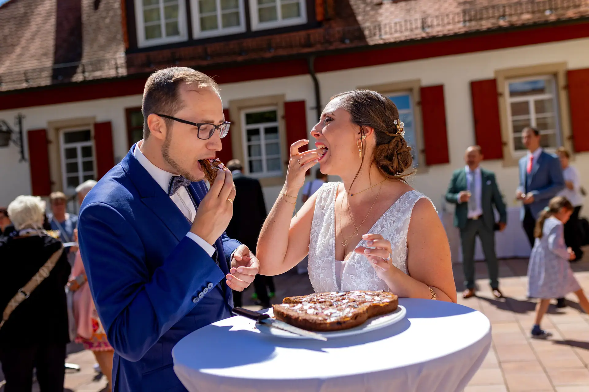 Verena Florian Mutterstadt Torte Teilen.CnADbNKi Brautpaar teilt gemeinsam ein Stück Hochzeitstorte vor der Kirche in Mutterstadt