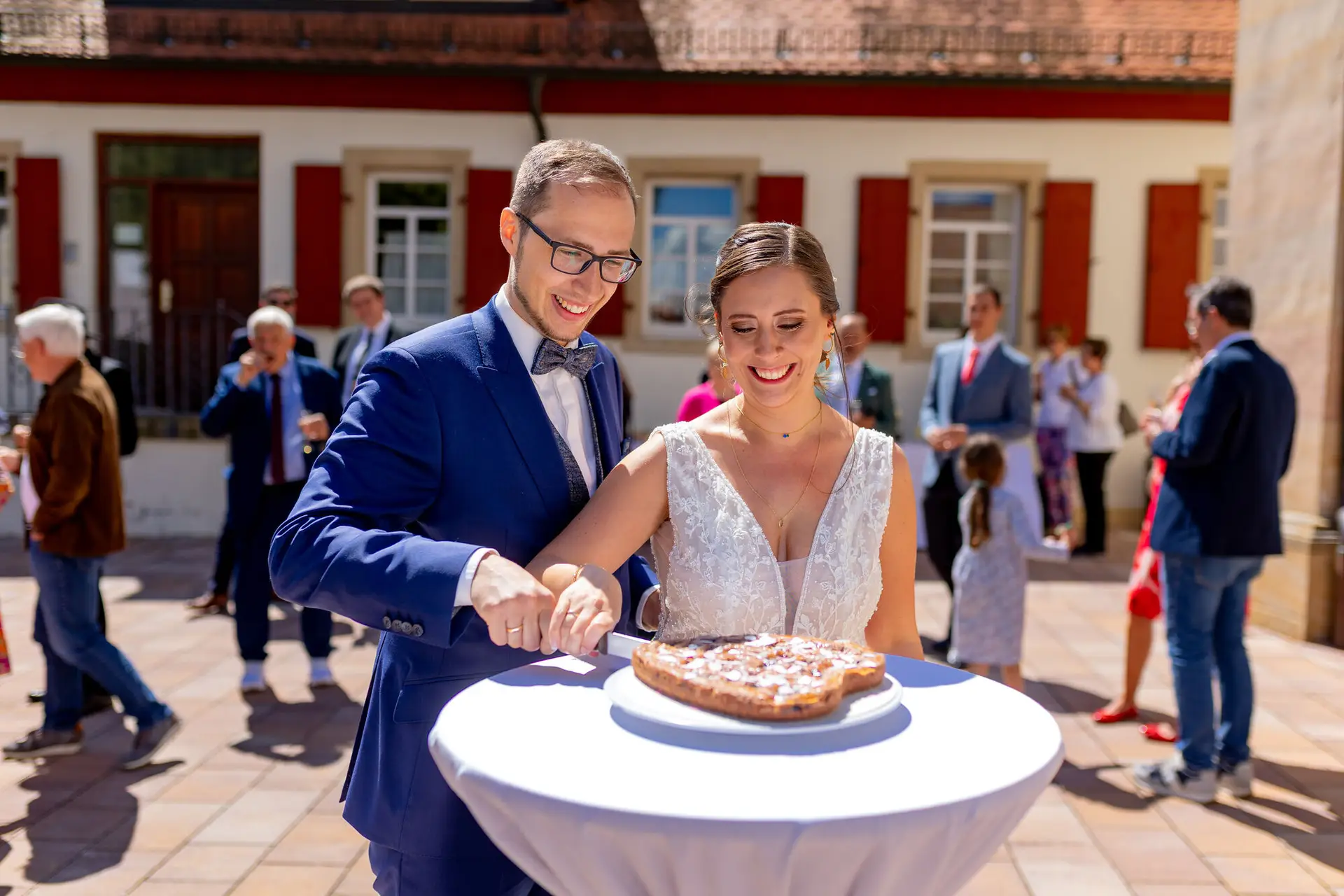 Verena Florian Mutterstadt Tortenanschnitt Lachend.3LWLe50K Brautpaar schneidet lachend die Hochzeitstorte vor der Kirche in Mutterstadt