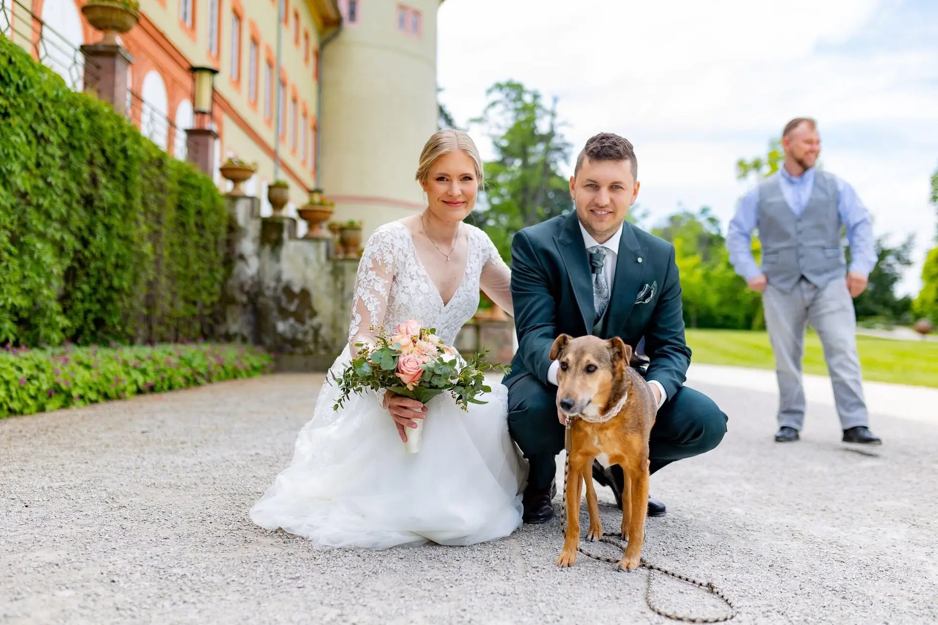 Brautpaar mit ihrem Hund auf dem Weg vor dem Schloss Herrnsheim