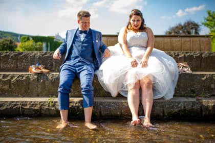 Hochzeitsfotograf in Bad Dürkheim: Brautpaar sitzt barfuß auf einer Steintreppe im Kurpark und genießt den Moment am Wasser nach der Trauung.