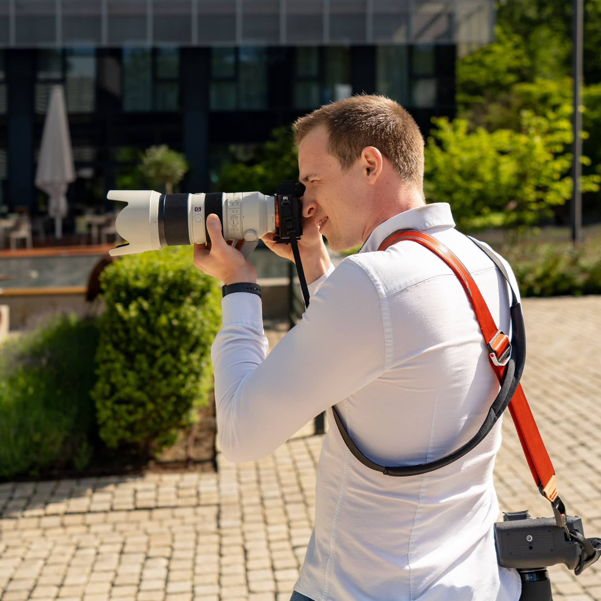 Business-Fotograf bei einer Veranstaltung der Lufthansa: Fotograf mit Teleobjektiv und Kamera fotografiert im Außenbereich eines Hotels.