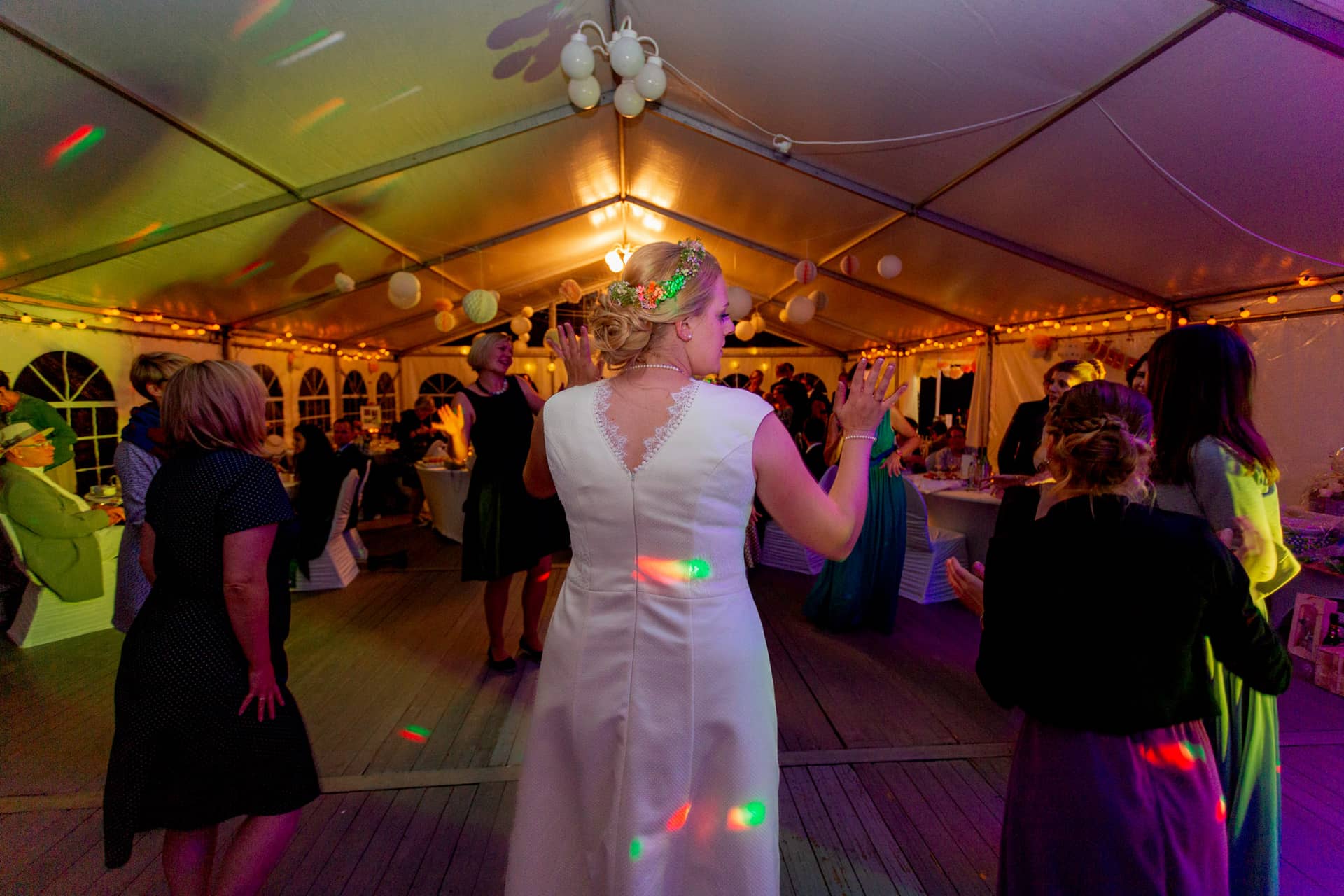 20180915 22 04 54 MK3 8784 Hochzeit Tanz Party Lichter Hochzeitsfotograf Reilingen Speyer Ida Philipp.B8gZtzfB Braut tanzt ausgelassen mit Gästen unter einem beleuchteten Festzelt