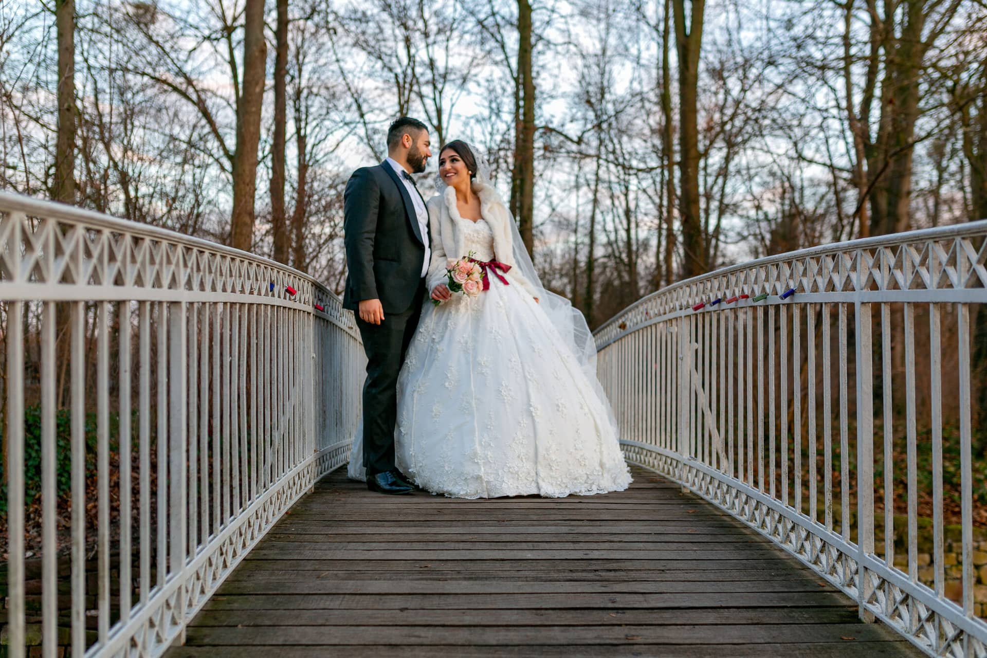 20181225 17 04 53 MK3 4591 Brautpaarshooting Worms Hochzeitsfeier Mannheim.BEo23IVc Brautpaar auf einer Holzbrücke im Wald, kahle Bäume formen einen natürlichen Rahmen um das Paar