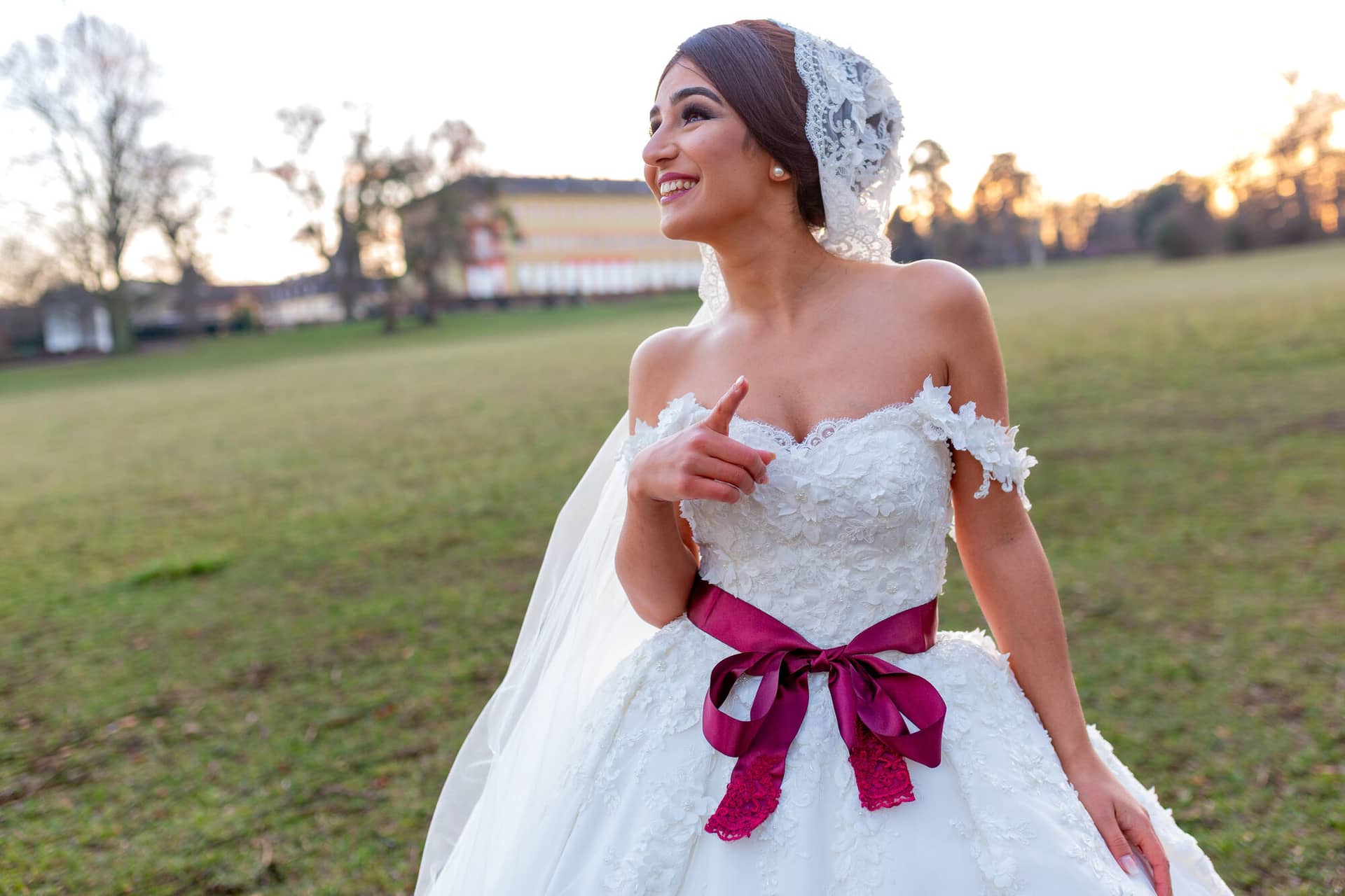 20181225 17 19 27 MK3 4717 Brautpaarshooting Worms Hochzeitsfeier Mannheim.B4L562G8 Braut im weißen hochgeschnittenen Hochzeitskleid mit rotem Satinband, elegante Detailaufnahme des Kleides