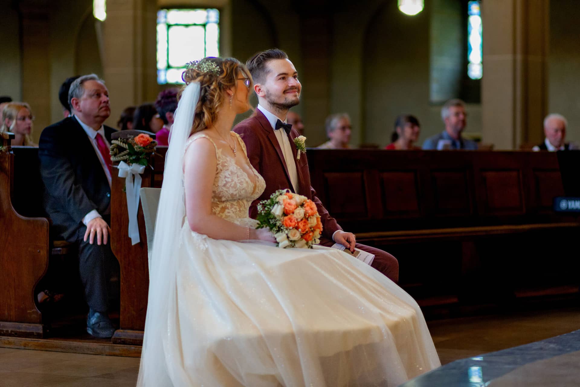 20230610 13 06 25 MK3 9896 Hochzeitsfotograf Mannheim Christuskirche Neuleiningen Burgschenke.D5TDHEkP Braut und Bräutigam sitzen nebeneinander im gotischen Kirchenschiff der Christuskirche während der Zeremonie