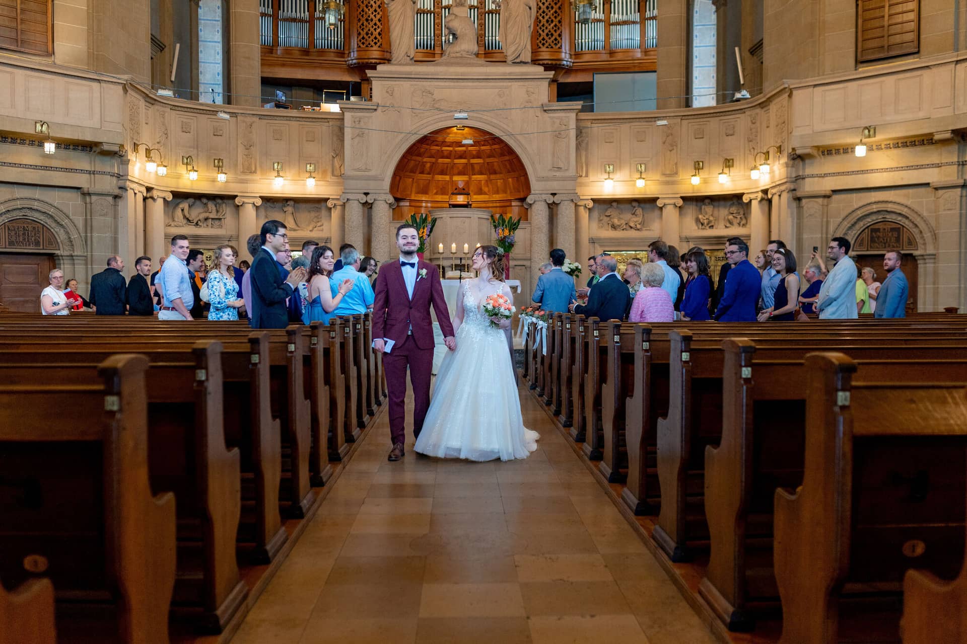 20230610 13 53 26 4K8A9637 Hochzeitsfotograf Mannheim Christuskirche Neuleiningen Burgschenke.CrQbsqrT Brautpaar schreitet durch den gotischen Kirchenraum, umgeben von Gästen nach der Trauung