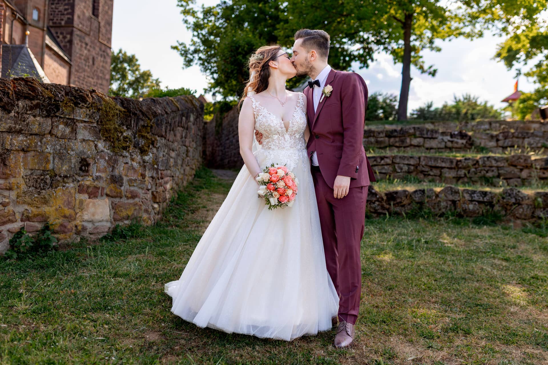 20230610 17 53 15 4K8A3562 Hochzeitsfotograf Mannheim Christuskirche Neuleiningen Burgschenke.Dxh2 Wrj Braut und Bräutigam küssen sich innig vor dem moosbewachsenen Mauerwerk der Burg Neuleiningen