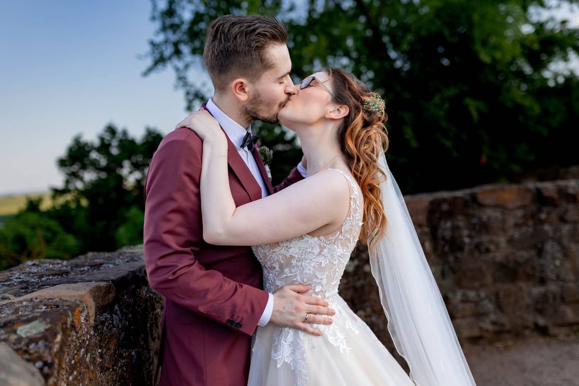 20230610 18 08 20 4K8A4236 Hochzeitsfotograf Mannheim Christuskirche Neuleiningen Burgschenke.CoXEN FK Brautpaar küsst sich unter dem grasbewachsenen Burghügel, romantische Stimmung im Außenbereich der Burg