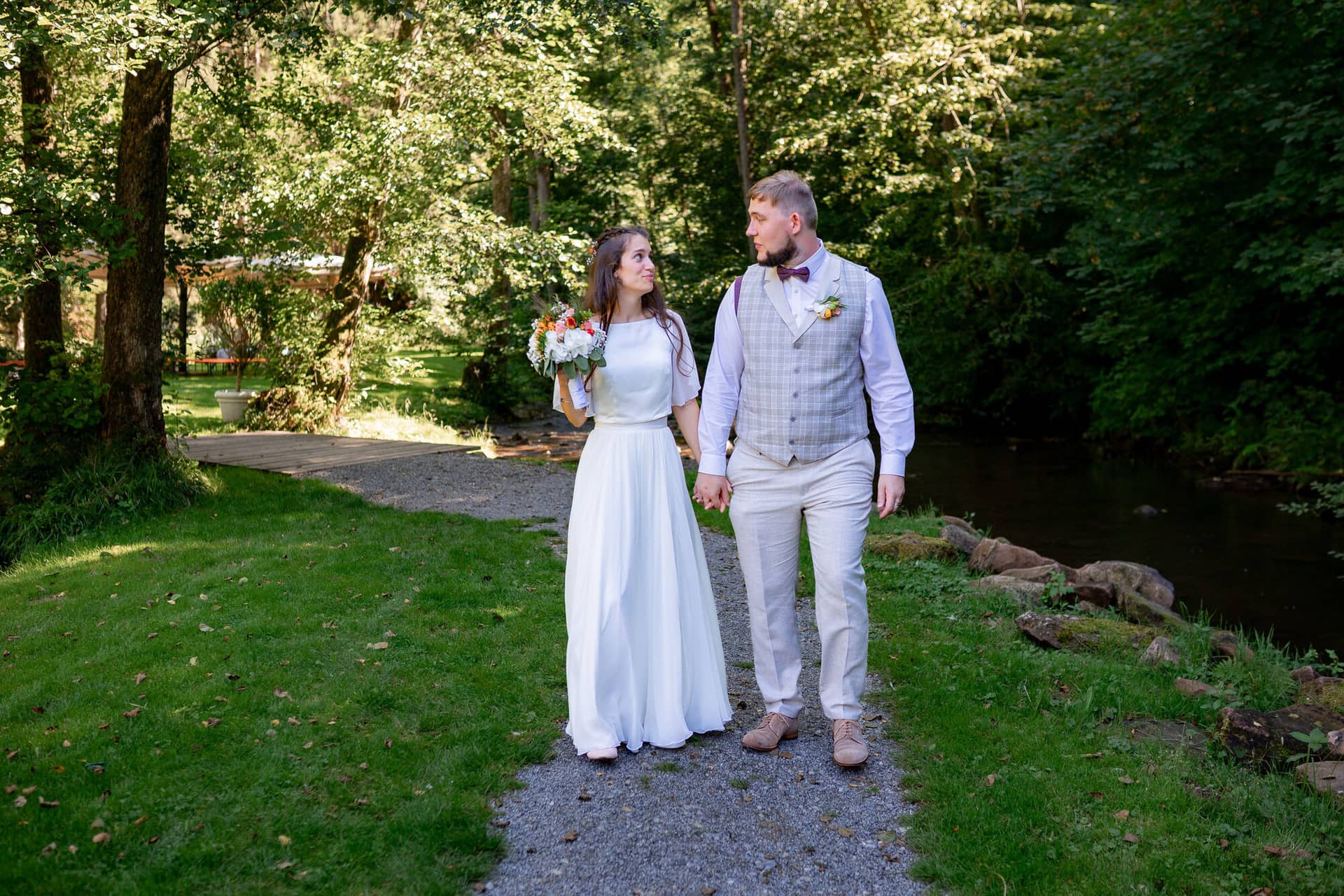 20230811 15 31 58 Hochzeit Elztal Hochzeitsfotograf Heiraten Heidelberg Landgasthof Heidersbacher Muehle 4K8A4428.D 22WAzP Brautpaar schreitet zusammen durch jubelnde Gäste mit Seifenblasen beim festlichen Auszug