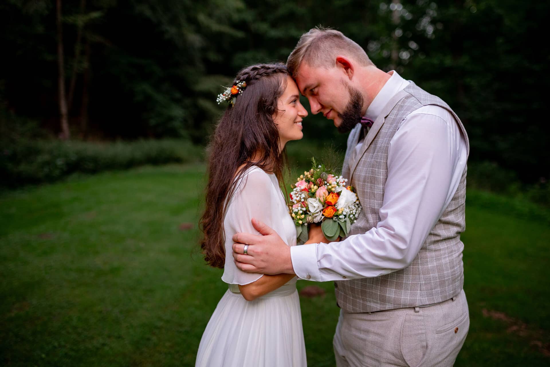 20230811 20 46 43 Hochzeit Elztal Hochzeitsfotograf Heiraten Heidelberg Landgasthof Heidersbacher Muehle 4K8A8109.Yr0oNNtD Brautpaar im abendlichen Elztal-Wald, Bräutigam hält Braut mit Blumenkrone liebevoll
