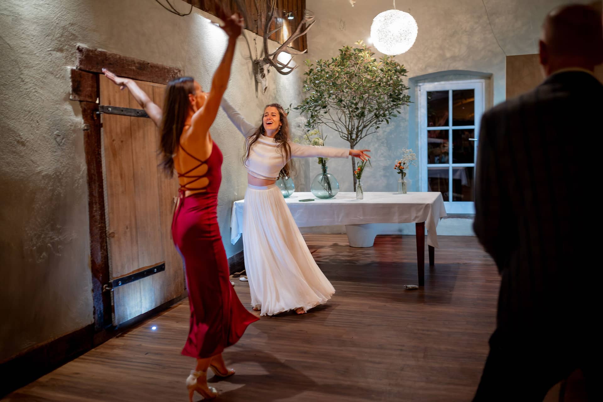 20230811 23 02 15 Hochzeit Elztal Hochzeitsfotograf Heiraten Heidelberg Landgasthof Heidersbacher Muehle 4K8A0377 2 Verbessert RR.C1LwCTXU Braut springt freudig in die Luft, Brautjungfer in Rot im Hintergrund – Energie pur bis in die Nacht