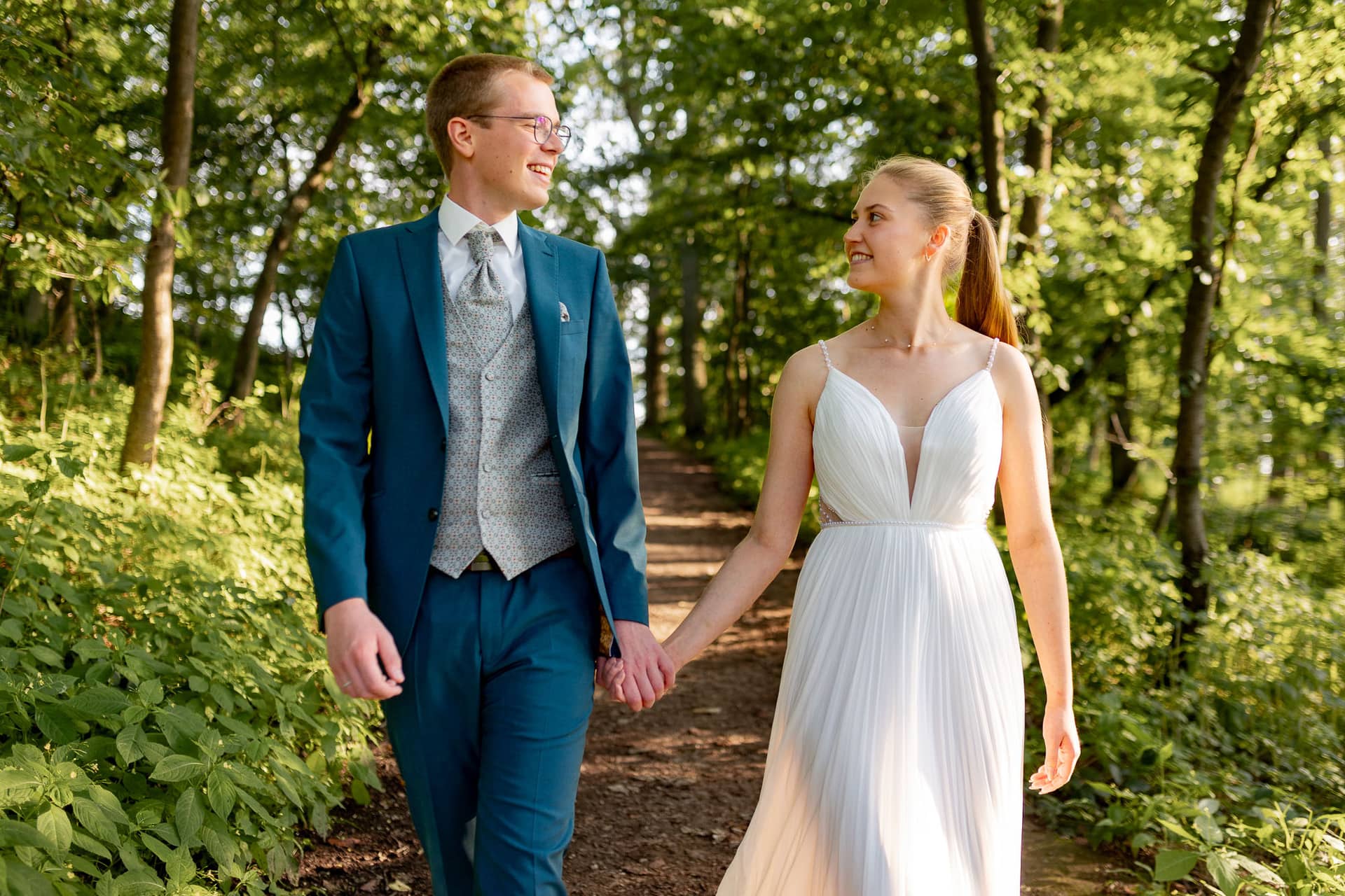 20240728 19 08 41 Ropertz Bad MüNster Ebernburg 4K8A1743.BkYMovUl Brautpaar läuft Hand in Hand durch sommerlichen Wald bei Burg Ebernburg