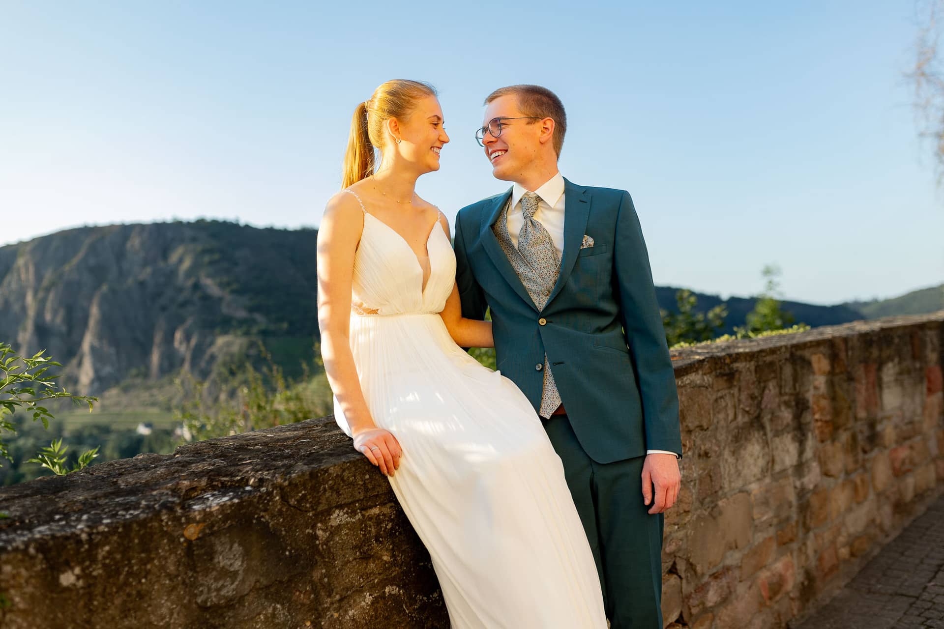 20240728 20 08 51 Ropertz Bad MüNster Ebernburg 4K8A2296.Bp ED2Mk Brautpaar lächelt sich an mit Panoramablick über Bad Münster am Stein-Ebernburg im Abendlicht