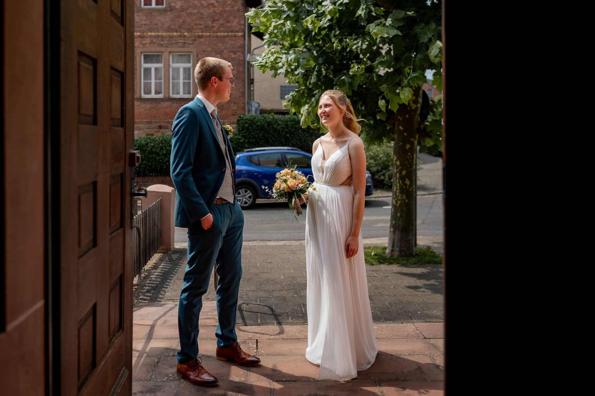 20240803 125438 4K8A3155.CCiC8Pky Brautpaar strahlt beim Auszug aus der Kirche St. Johannes der Täufer in hellem Sonnenlicht