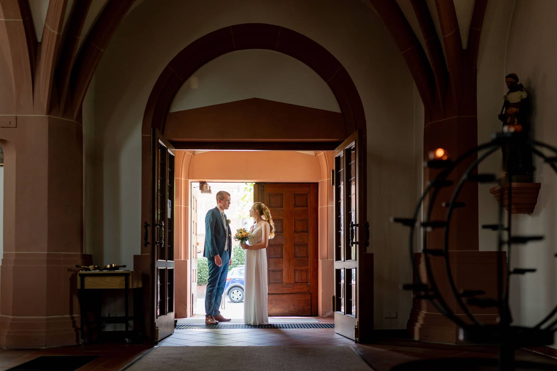 20240803 125606 4K8A3204.N K8YWvf Brautpaar steht vor dem gotischen Eingangstor der Kirche St. Johannes der Täufer in Bad Münster