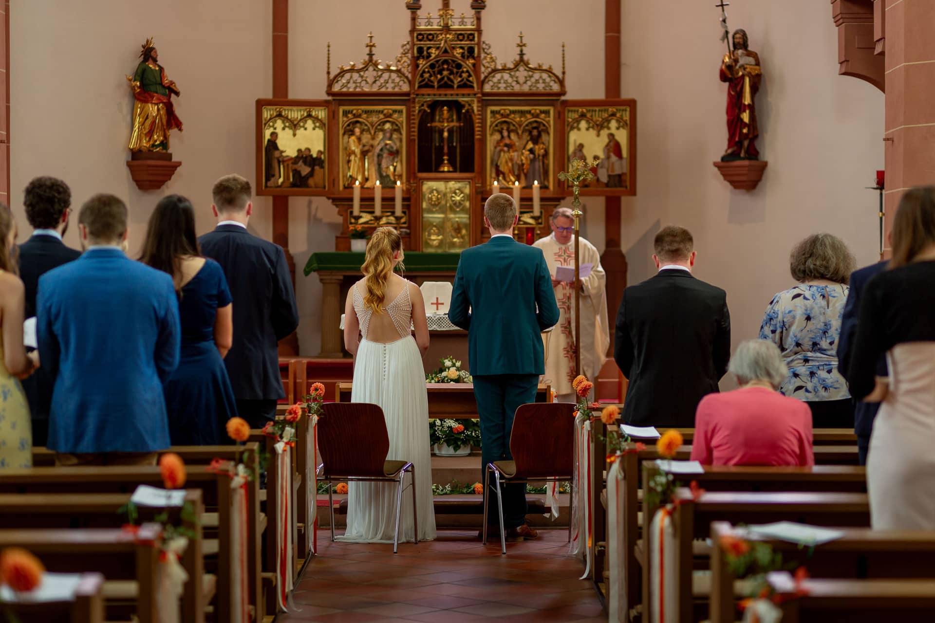 20240803 130056 MK3 6337.Ux9b1qwJ Brautpaar mit Trauzeugen vor dem festlich geschmückten Altar in St. Johannes der Täufer
