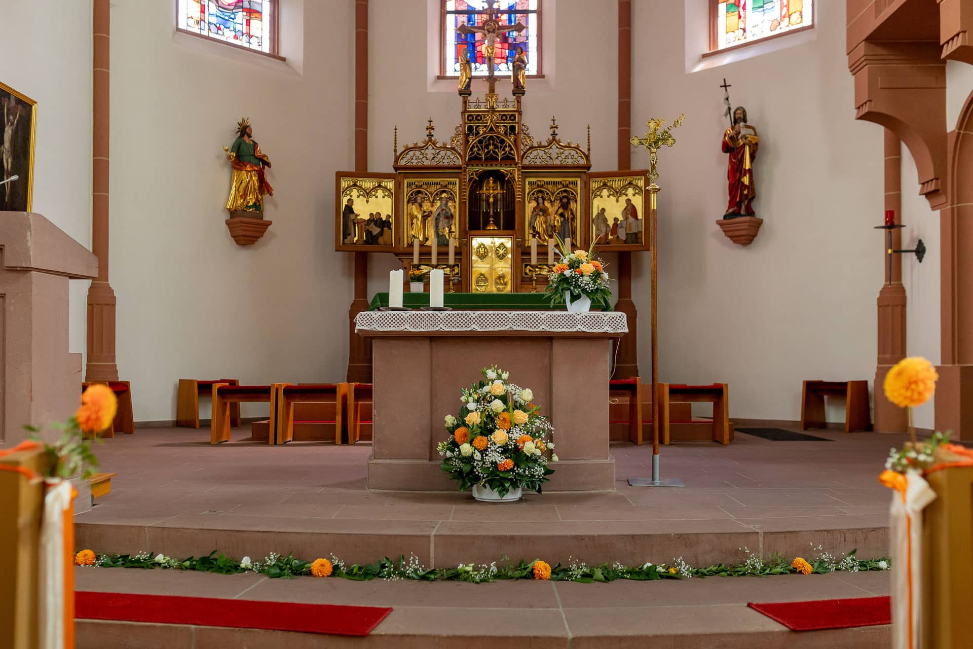 20240803 141200 4K8A7204.CTIo4FBj Festlich geschmückter Altar mit Orangeblüten und Kerzen in der Kirche St. Johannes der Täufer