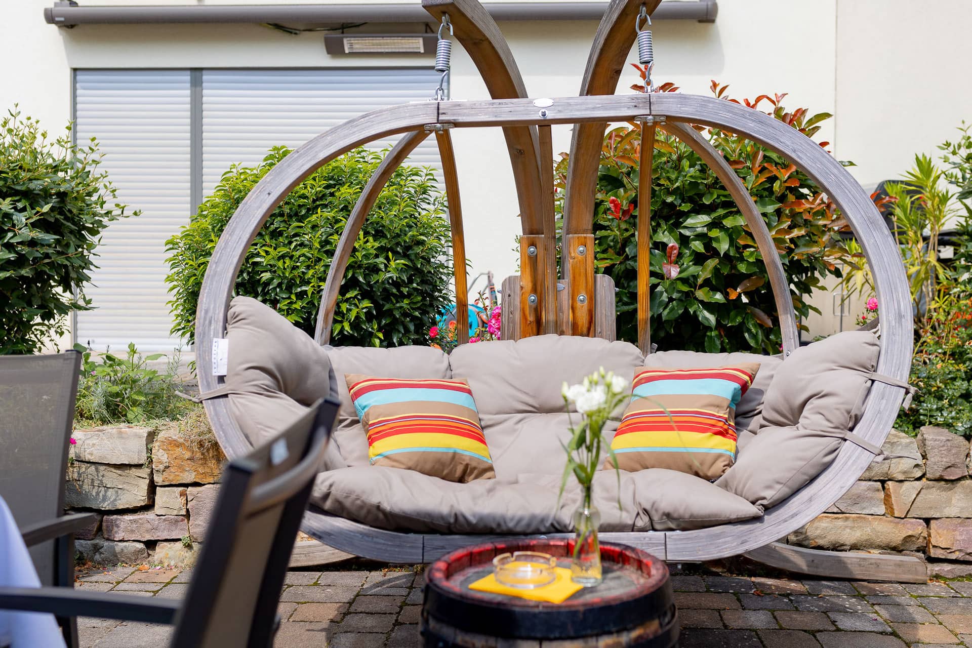 20240803 144209 4K8A7366.C5KkvakF Gemütliche Sitzecke mit bunten Kissen und Kerzen vor Steinmauer bei der Hochzeitsfeier