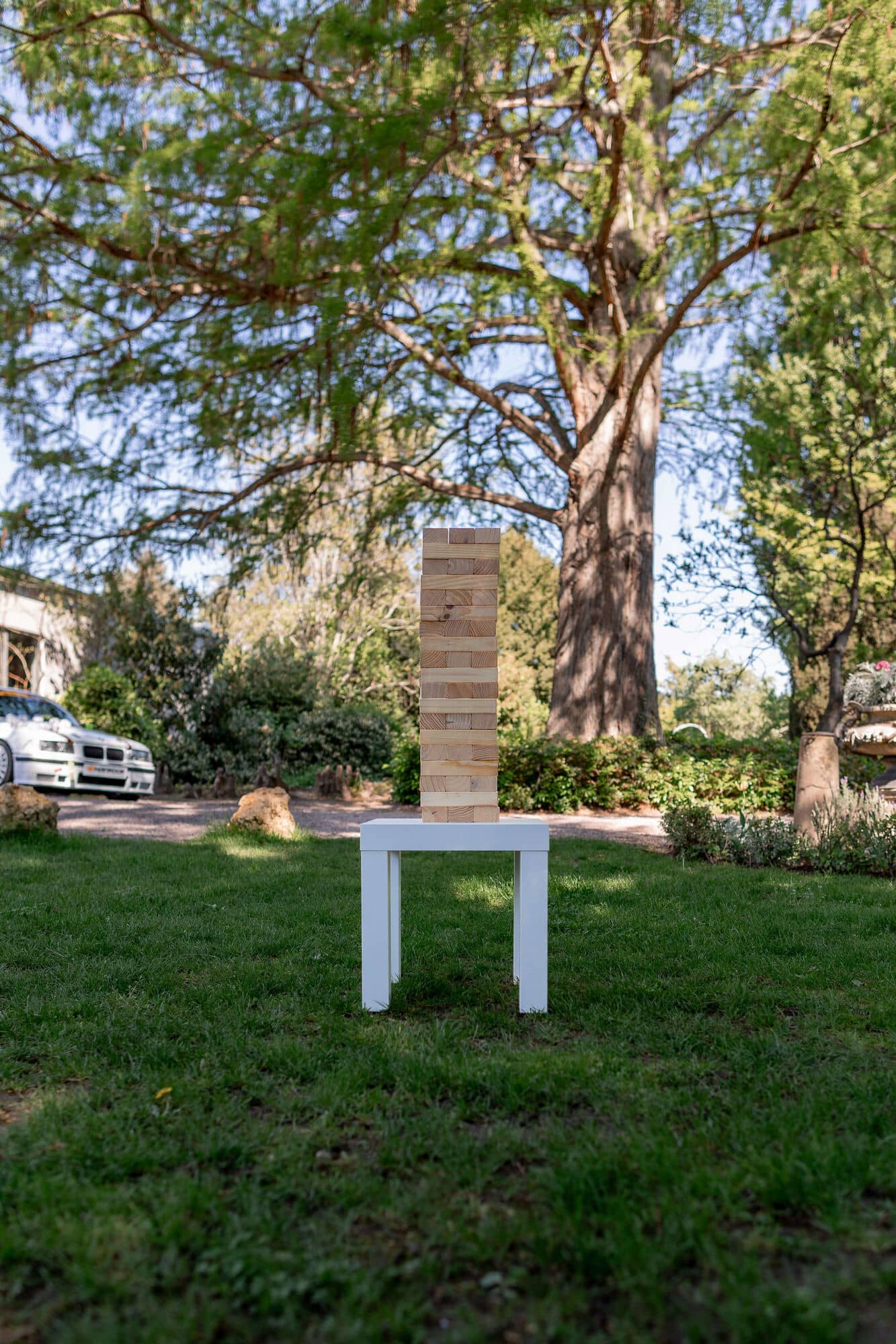 20250501 11 09 294K8A2209 Hochzeitslocation Bad Duerkheim Fritz Ritter Weingut.CDzaLbqg Jenga-Turm als Hochzeitsspiel auf weißem Beistelltisch im Gutsgarten