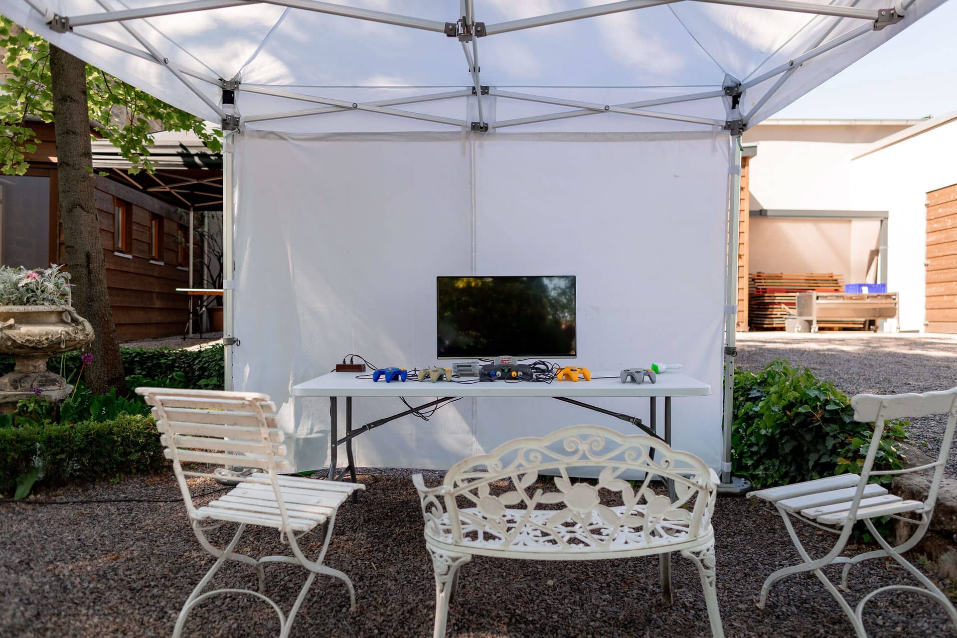 20250501 11 10 164K8A2220 Hochzeitslocation Bad Duerkheim Fritz Ritter Weingut.BuoLS0du Gaming-Station mit Konsolen unter weißem Pavillon-Zelt im Garten
