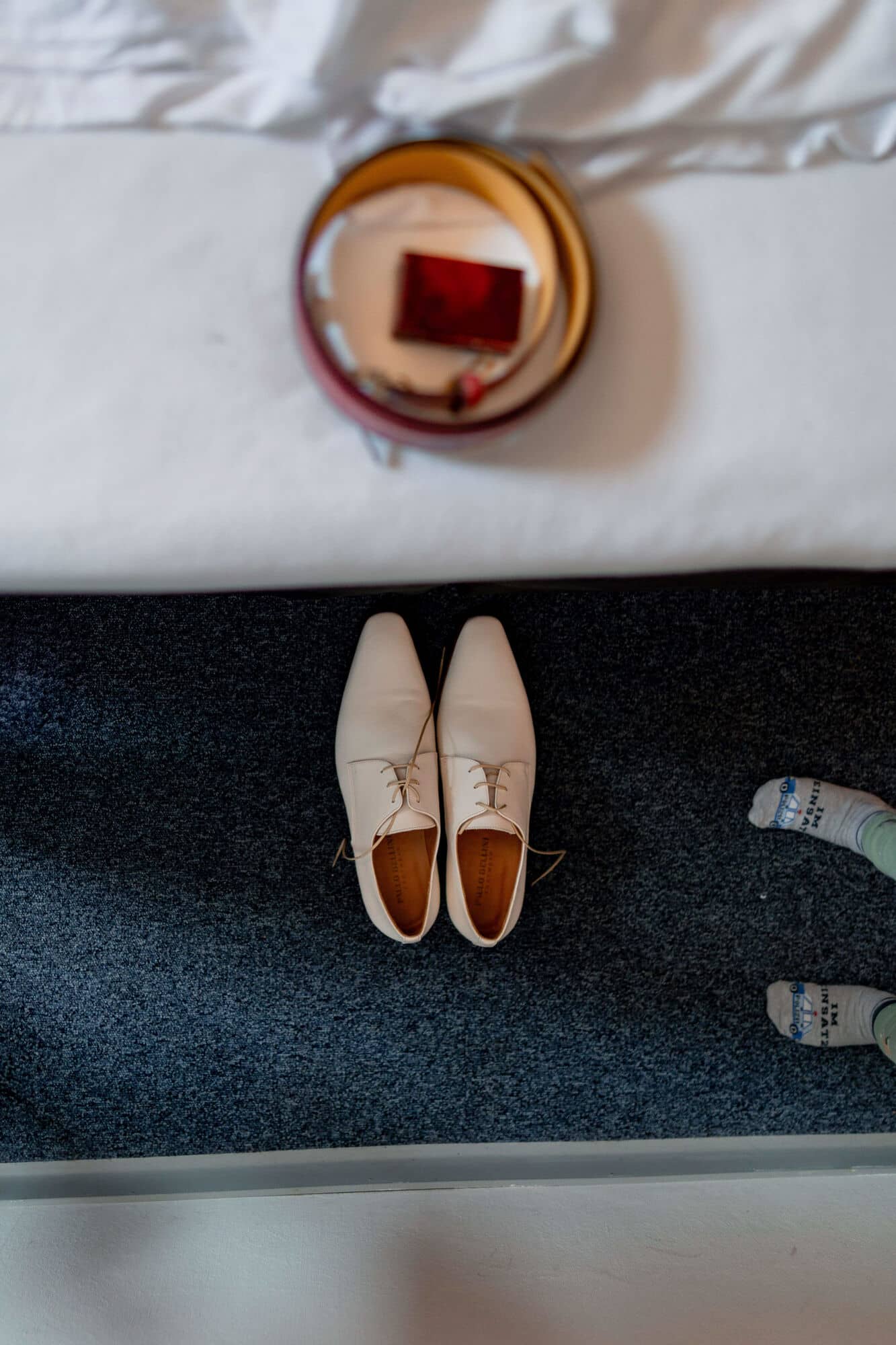 20250501 11 20 494K8A2307 Getting Ready Brautigam Bad Duerkheim.DXDKI7O0 Elegante beige Bräutigam-Schuhe mit braunen Details auf dunklem Hotelteppich