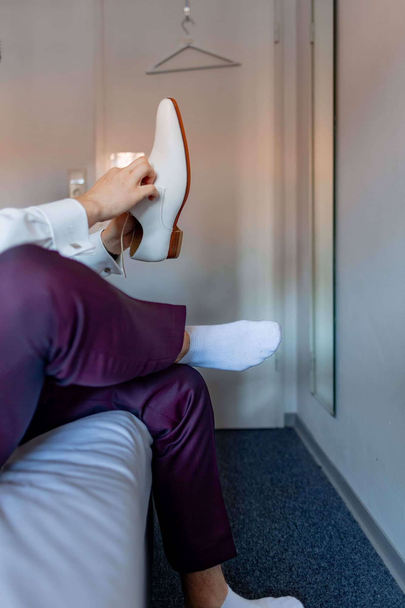 20250501 11 35 254K8A2453 Getting Ready Brautigam Bad Duerkheim.B7Z9lZpf Bräutigam hält beigen Lederschuh in den Händen beim Getting Ready