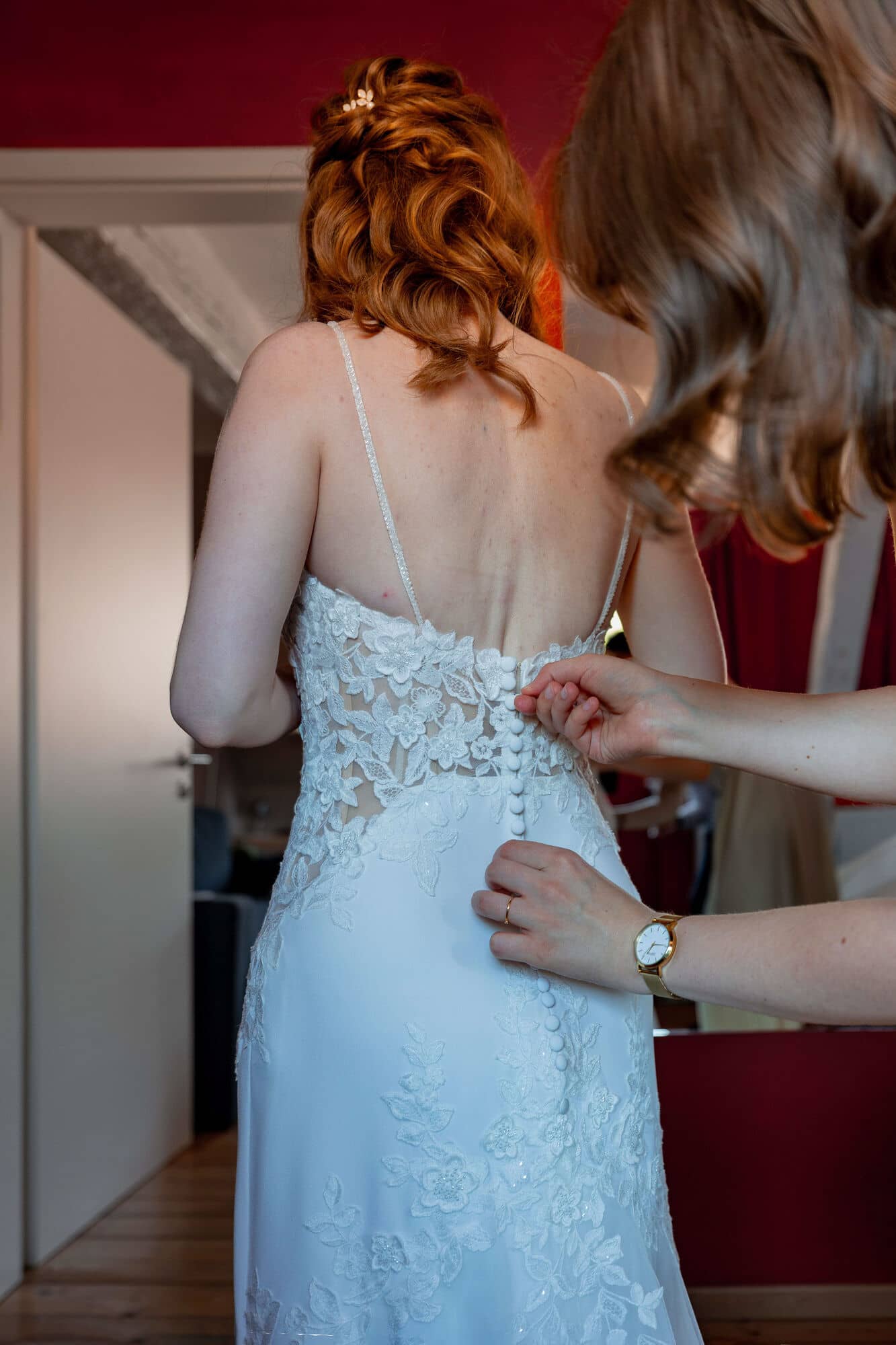 20250501 12 43 392C4A2971 Verbessert RR Getting Ready Der Braut Im Fritz Ritter In Bad Duerkheim.ZgYcBWhP Braut wird von Trauzeugin in das Spitzenkleid mit offenen Rücken geholfen