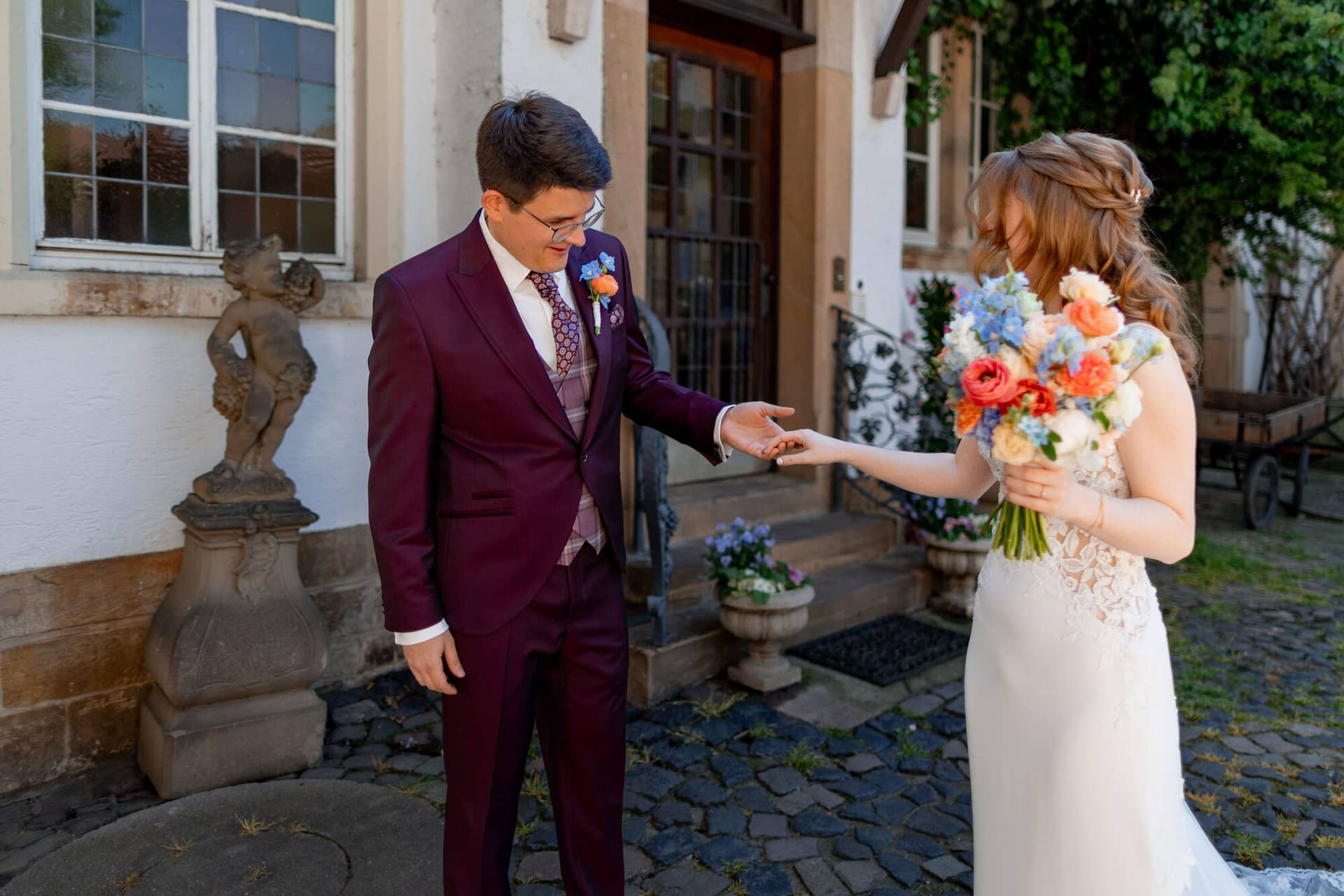20250501 13 52 154K8A2967 Als Hochzeitsfotograf Im Fritz Ritter In Bad Duerkheim.D L6JsWc Brautpaar küsst sich unter dekorativem Blumenbogen im romantischen Garten des Weinguts
