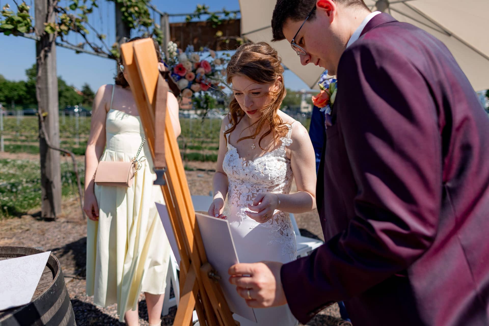 20250501 14 36 044K8A3356 Trauung Bad Duerkheim Fritz Ritter Hochzeitsfotograf.CHUKKj C Hochzeitsgast zeigt Spielkarte mit Namenskärtchen beim Memory-Spiel