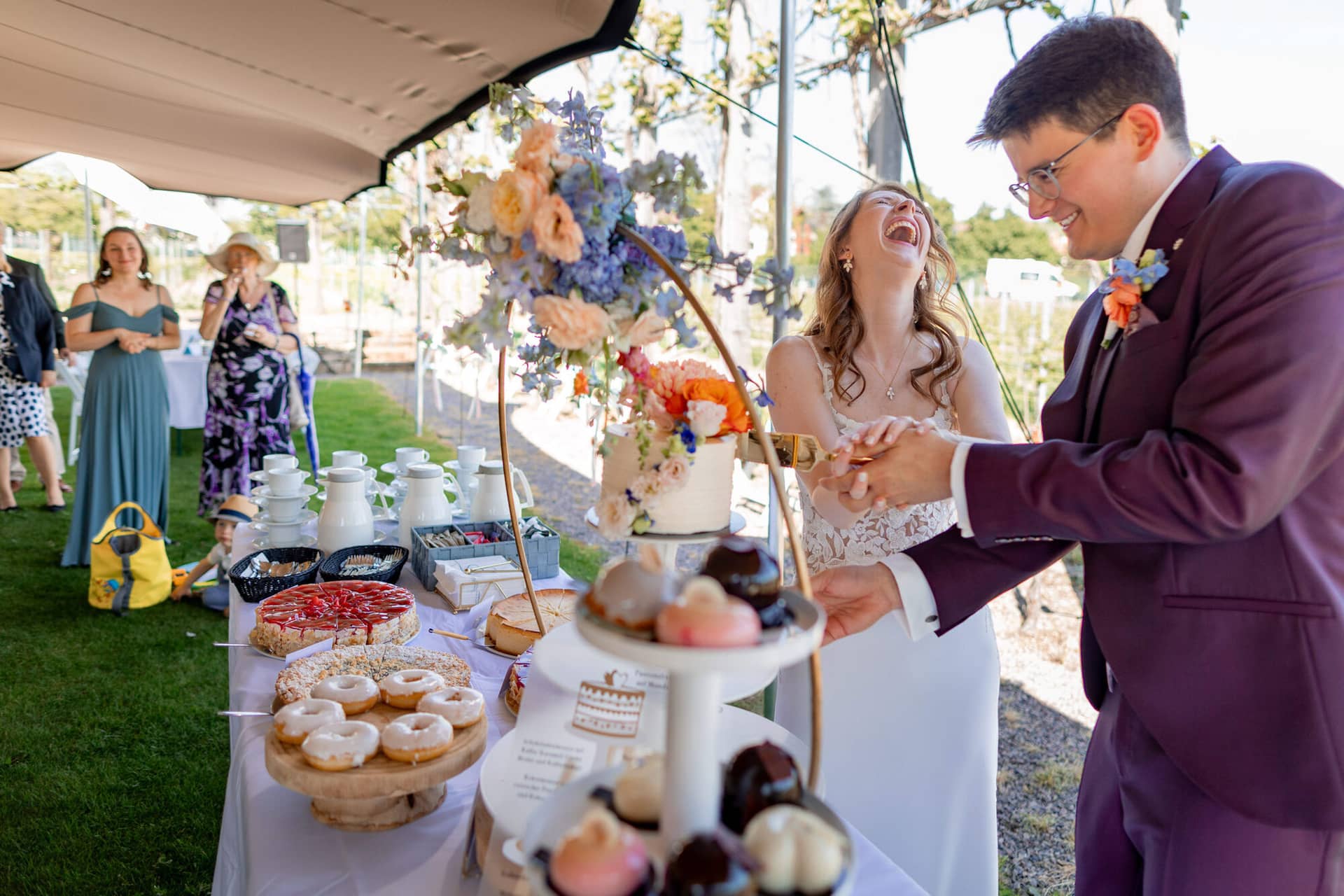 20250501 15 36 164K8A4879 Trauung Bad Duerkheim Fritz Ritter Hochzeitsfotograf.Bg94mk5f Braut und Trauzeugin lachen gemeinsam im Weinberg nach der Zeremonie