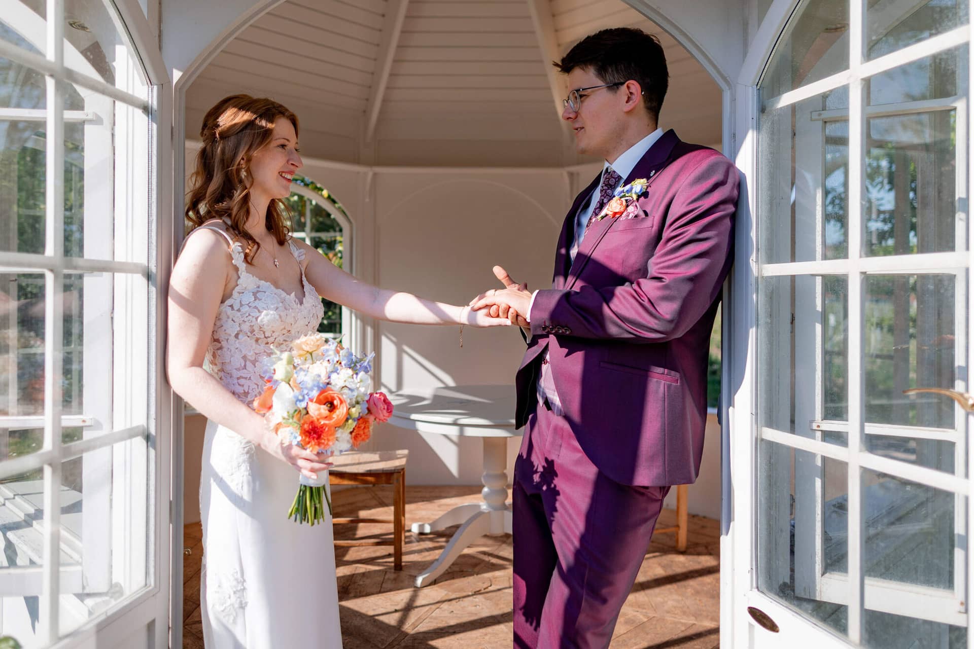 20250501 17 22 464K8A5376 Brautpaarshooting Bad Duerkheim Fritz Ritter Hochzeitsfotograf.MYqnpD5E Brautpaar in inniger Pose im lichtdurchfluteten weißen Gartenpavillon