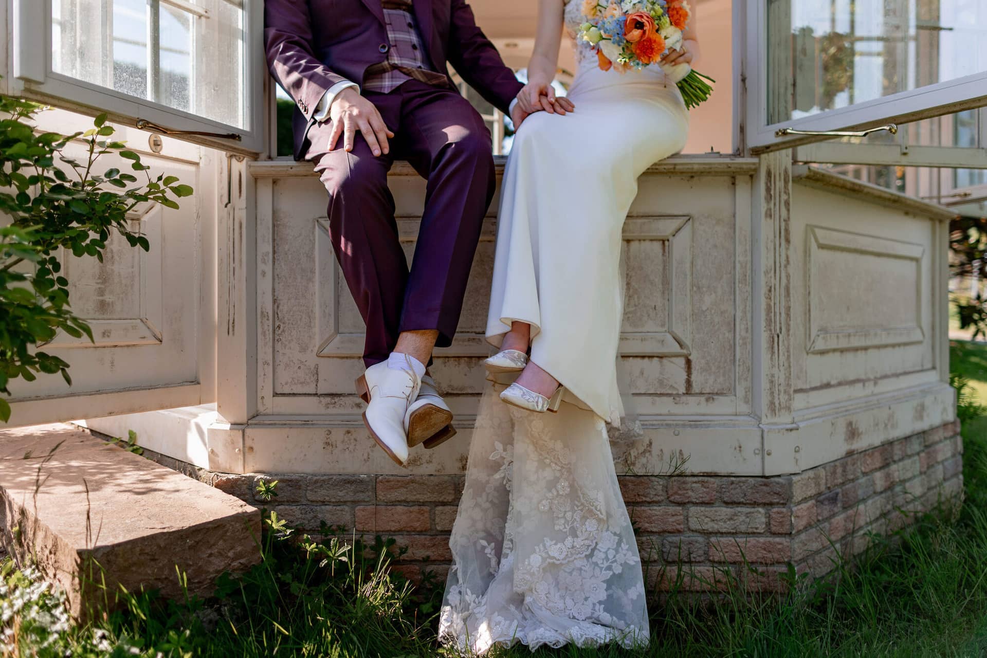 20250501 17 29 194K8A5639 Brautpaarshooting Bad Duerkheim Fritz Ritter Hochzeitsfotograf.DAxPFZko Detailaufnahme der Beine und weißen Schuhe des Brautpaars am Pavillon