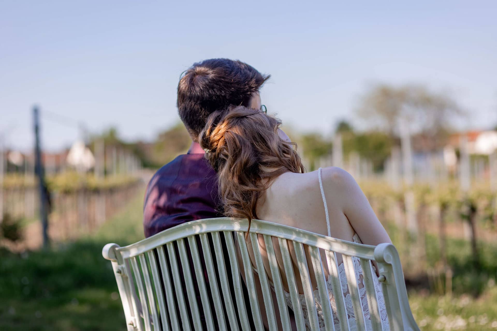 20250501 17 34 082C4A3685 Als Hochzeitsfotograf Im Fritz Ritter In Bad Duerkheim.DX2OV9Yb Brautpaar lehnt sich romantisch aneinander vor malerischer Weinberg-Kulisse