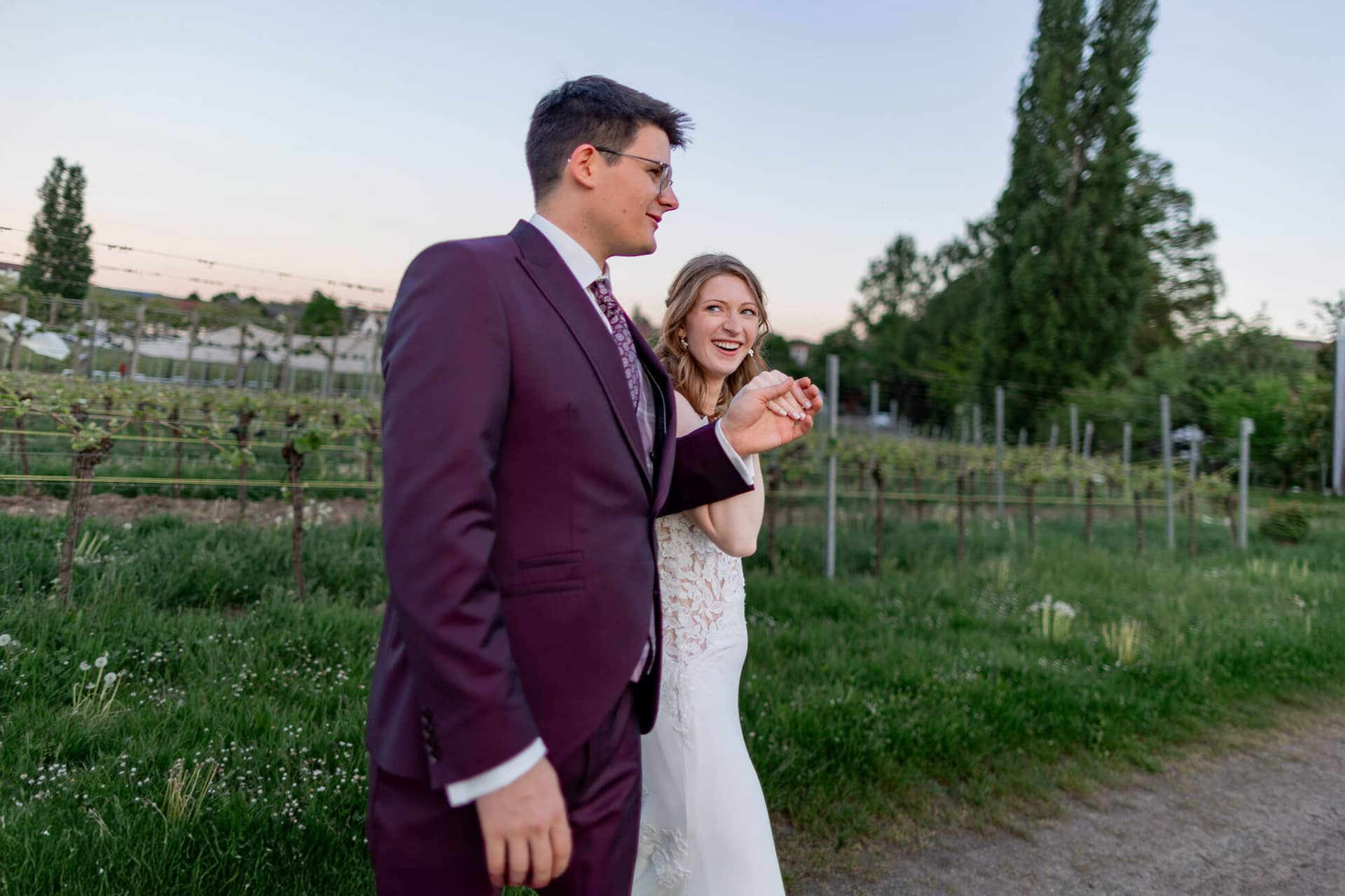 20250501 20 11 354K8A6690 Brautpaarshooting Sunnenuntergang Golden Hour Bad Duerkheim Fritz Ritter Hochzeitsfotograf.CQn7rb20 Brautpaar lacht gemeinsam beim Tanzen im warmen Abendlicht der Weinberge