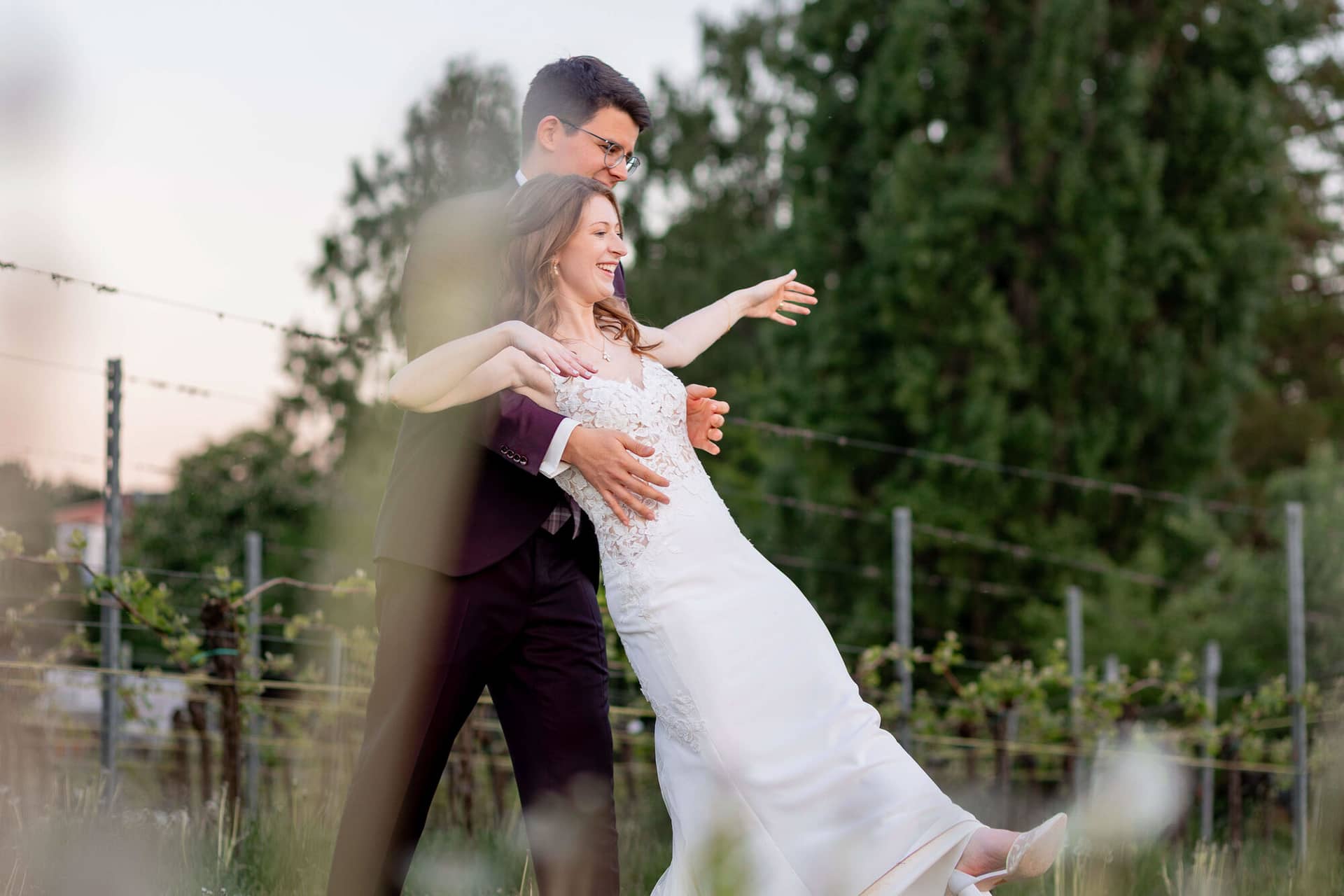 20250501 20 11 372C4A3875 Als Hochzeitsfotograf Im Fritz Ritter In Bad Duerkheim.BhD I5Fh Bräutigam trägt seine Braut während des ersten Tanzes im stimmungsvoll beleuchteten Festsaal