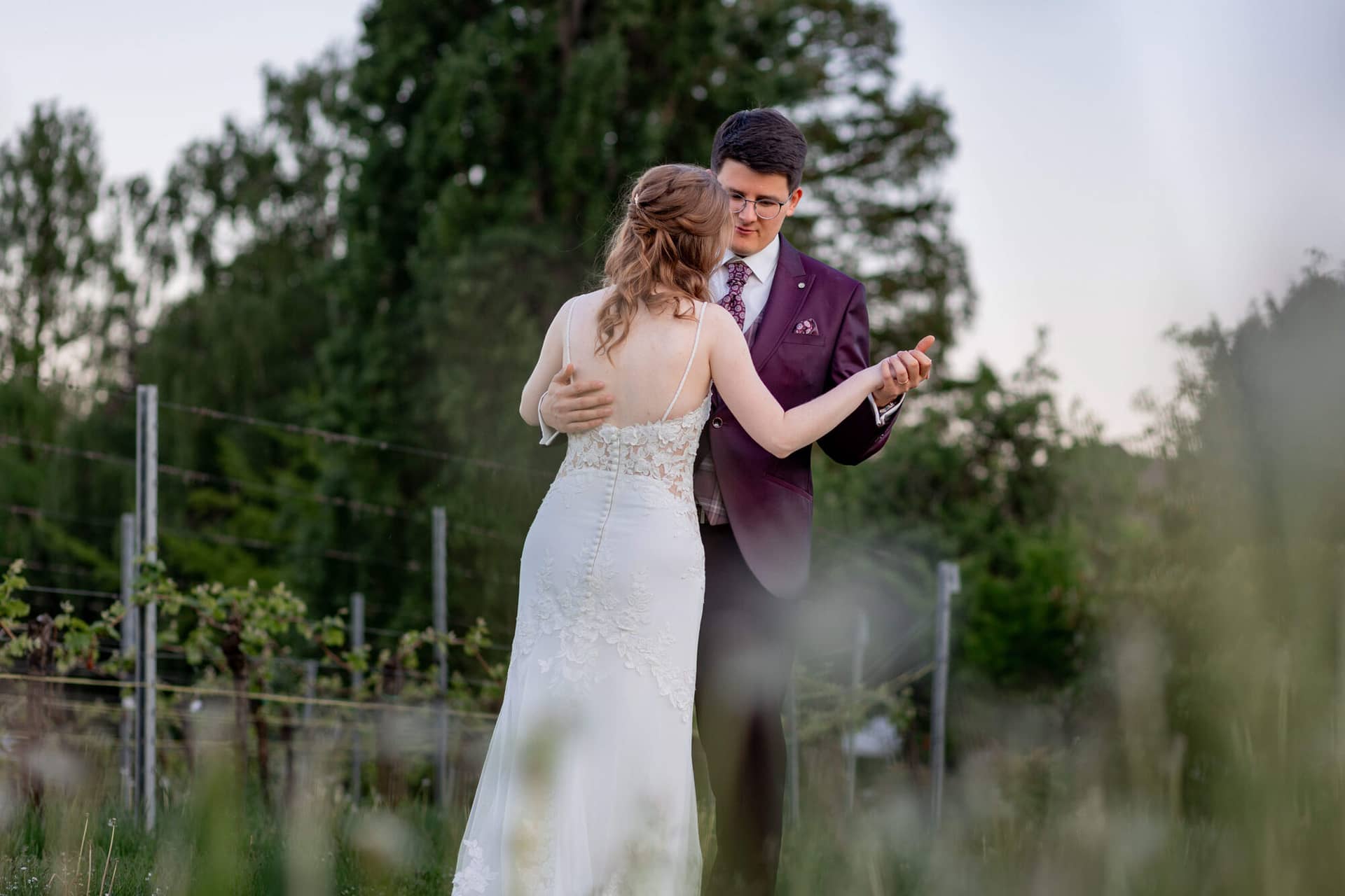 20250501 20 12 212C4A3917 Brautpaarshooting Sunnenuntergang Golden Hour Bad Duerkheim Fritz Ritter Hochzeitsfotograf.BkXRe9HA Verliebtes Brautpaar umarmt sich innig beim Tanzen im Weinberg bei Sonnenuntergang