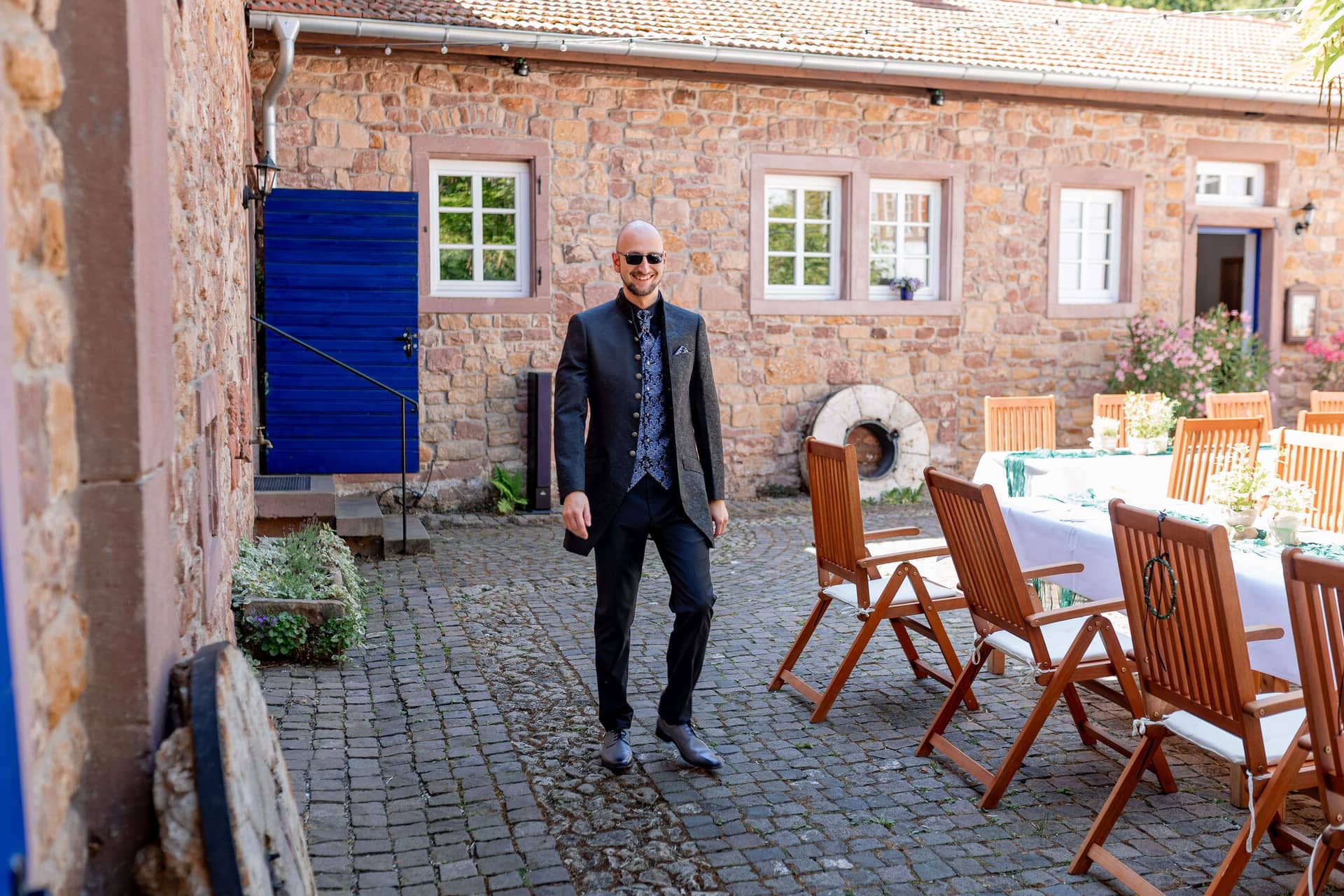 20250621 15 22 45 4K8A1750 Trauung Felsenmuehle Neuleinigen.CK71CD8N Bräutigam steht am Innenhof der Felsenmühle