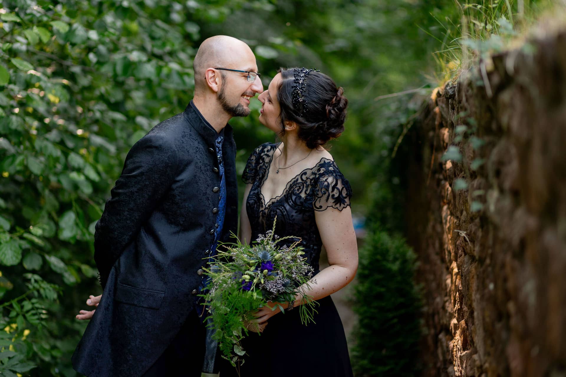 20250621 17 52 03 4K8A3619 Brautpaarshooting Felsenmuehle Neuleinigen.DoYrkPpS Brautpaar küsst sich unter der Laube