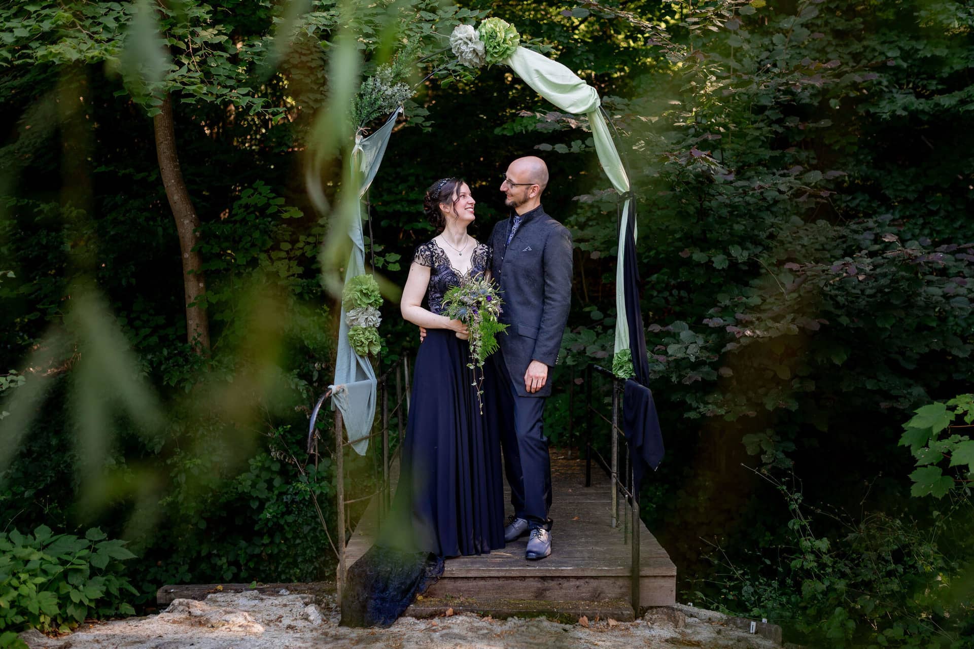 20250621 17 56 48 4K8A3777 Brautpaarshooting Felsenmuehle Neuleinigen.B8qYfxUM Braut und Bräutigam umarmen sich vor Steinmauer